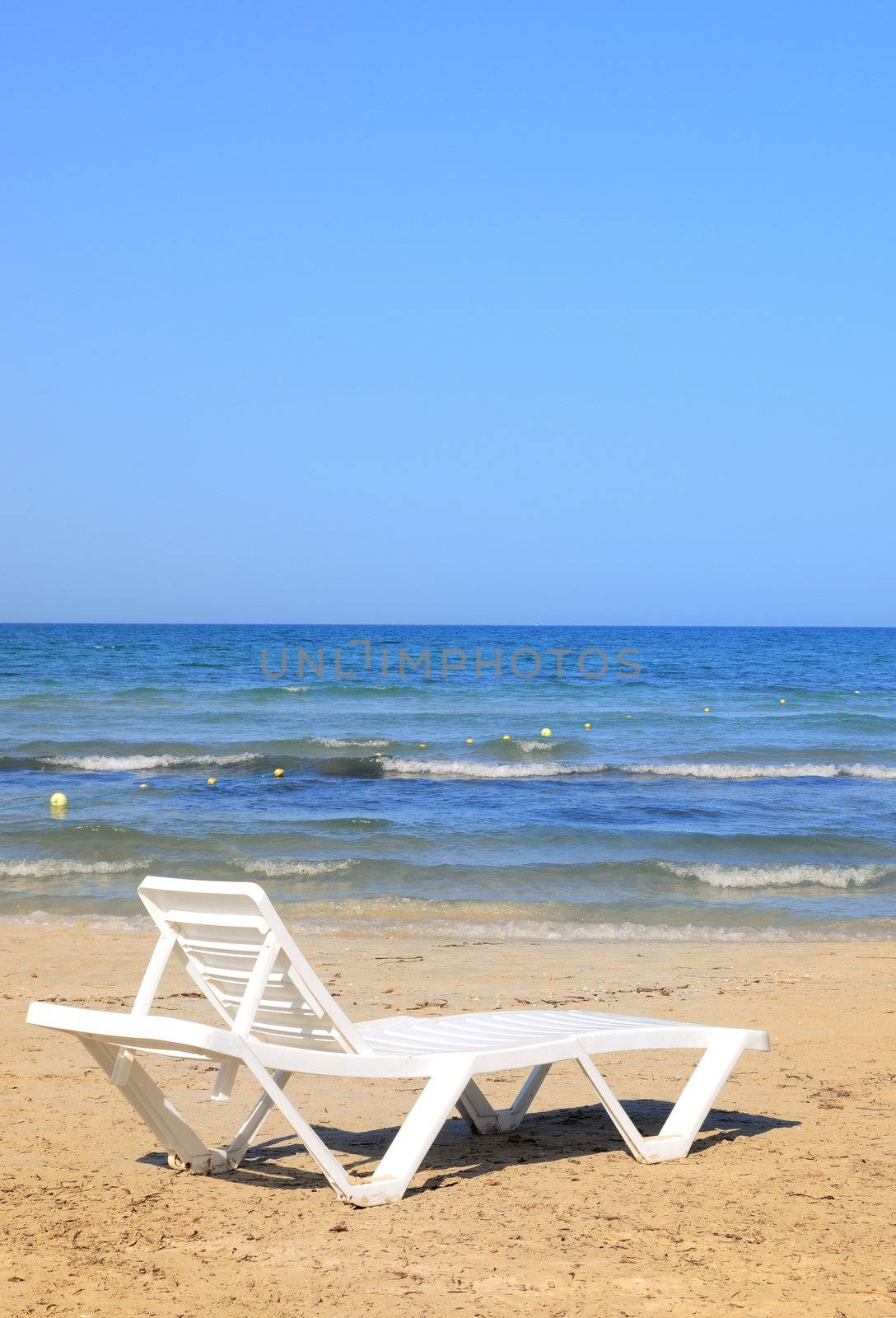 deckchairs on the beach under blue sky