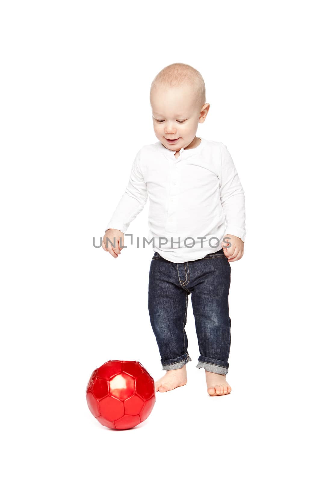 Boy playing with a red ball isolated against a white background