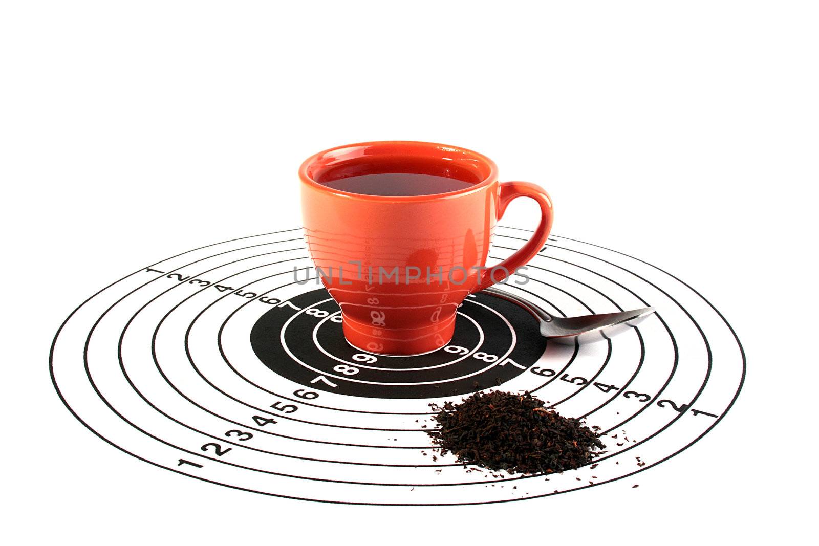 The red cup with tea is in the centre of a target for accuracy training, nearby there is a teaspoon and tea leaves are scattered. The creative with idea tea - hit in the purpose, tea is your choice.