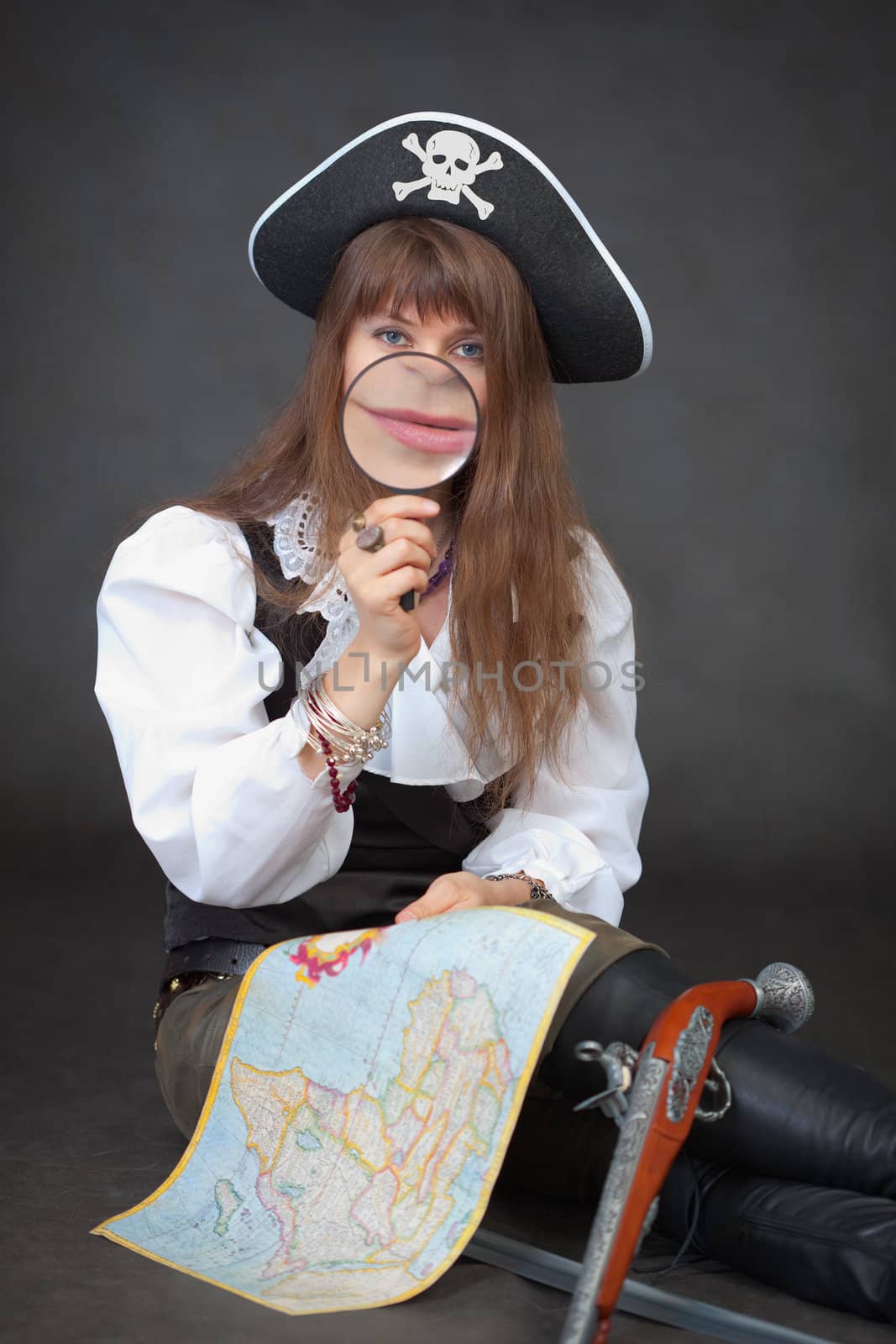 The woman - the captain of sea pirates with a map and a magnifier in hands