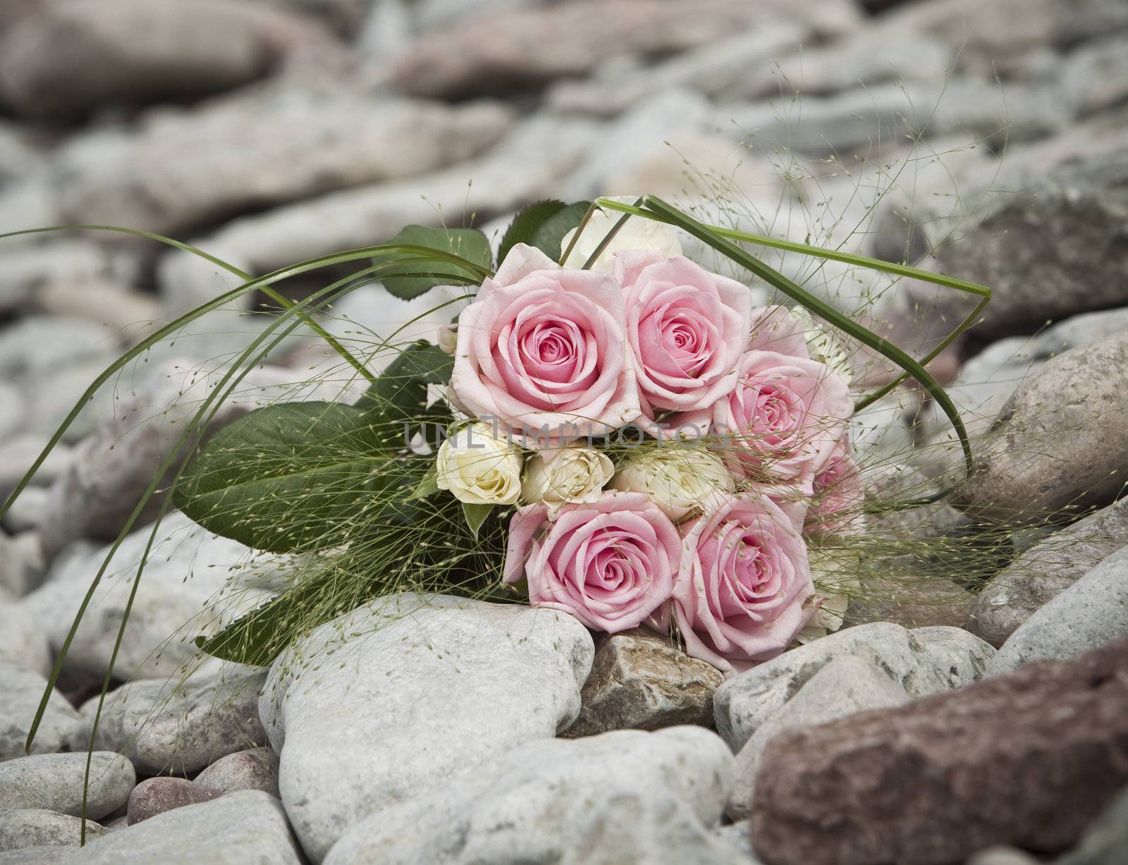 Bouquet of pink and white roses lying on rocks