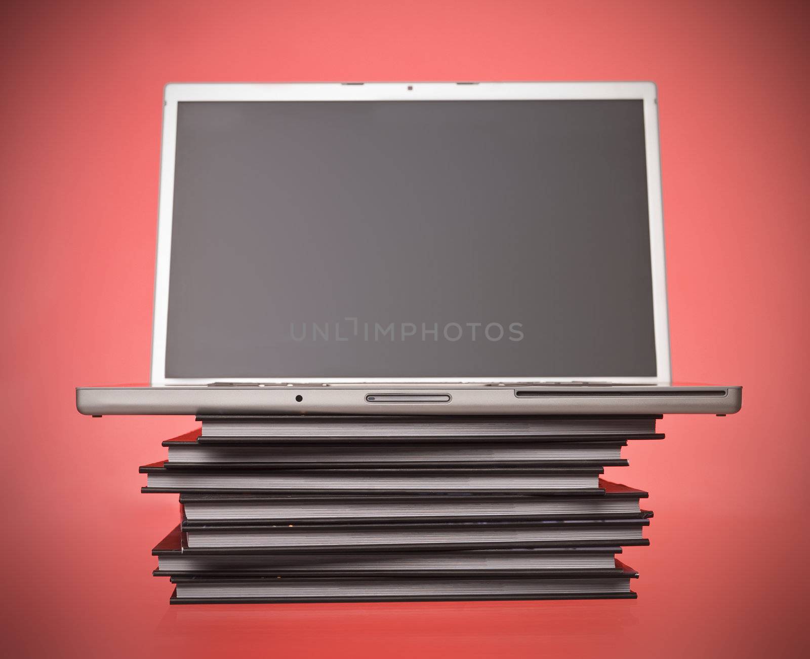 Laptop on top of a pile of books