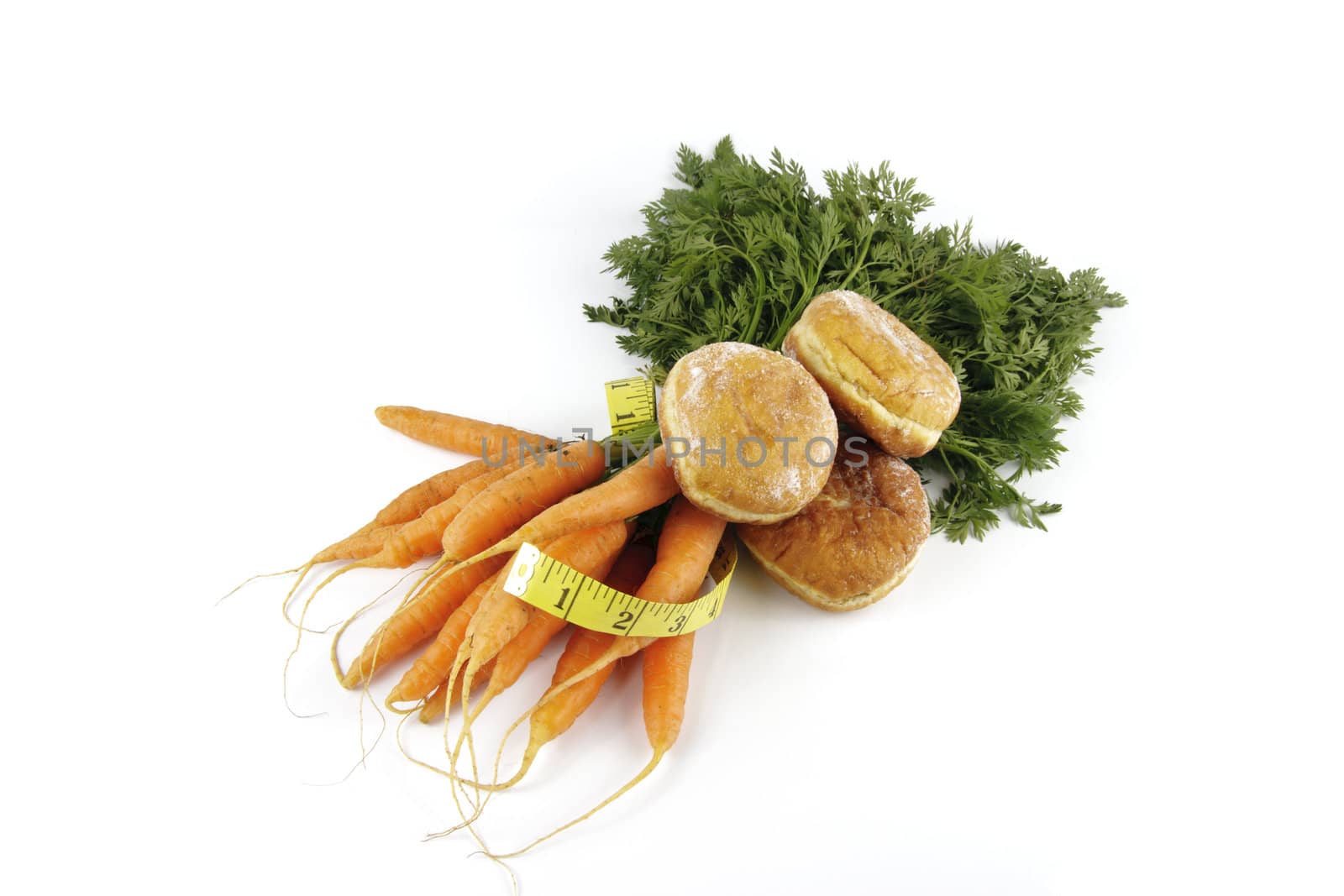 Contradiction between healthy food and junk food using bunch of carrots and doughnut with a tape measure on a reflective white background 