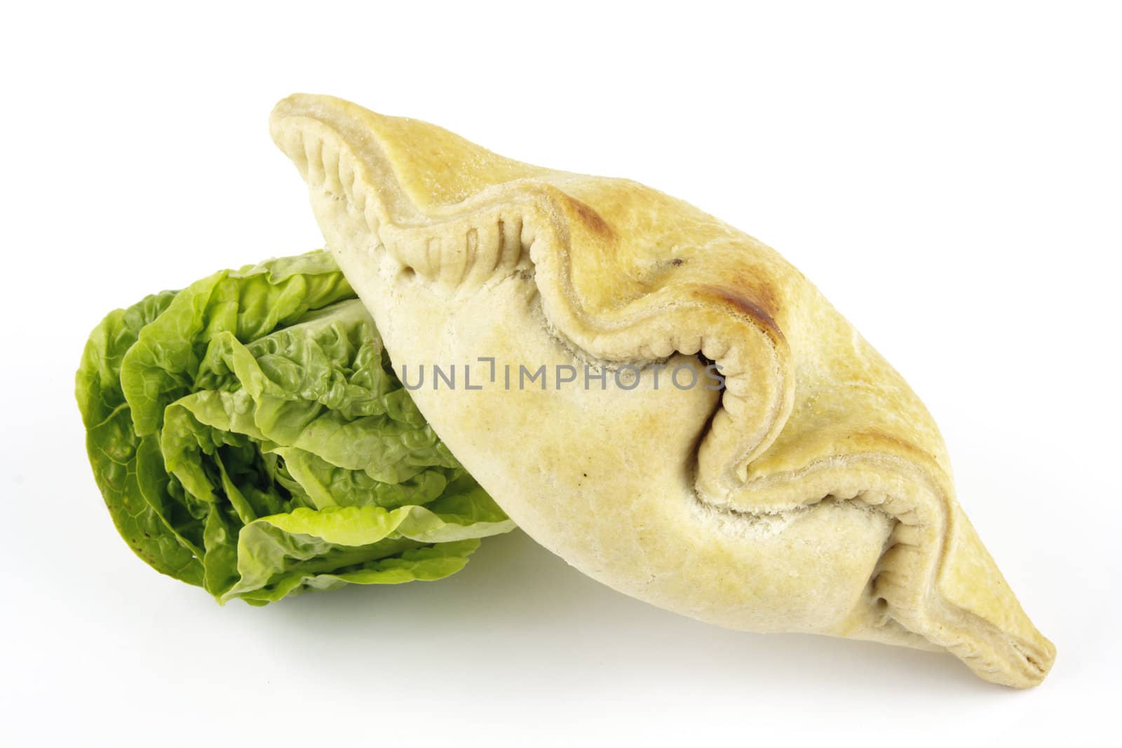 Contradiction between healthy food and junk food using a green salad lettace and pasty on a reflective white background 