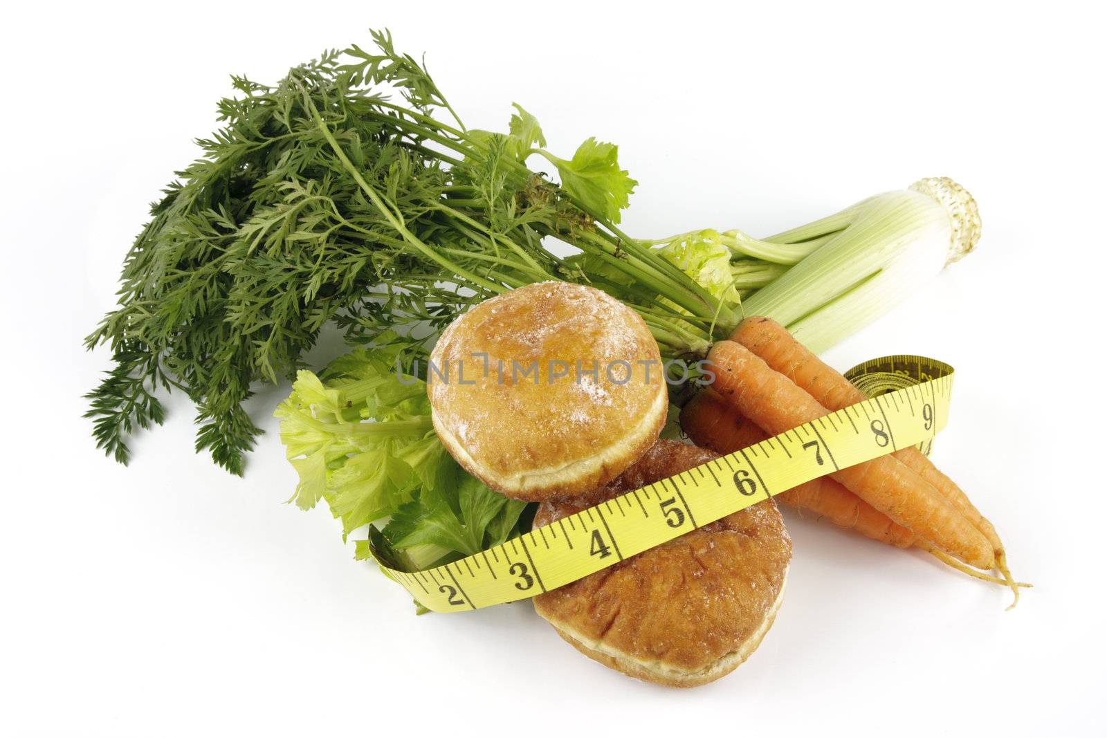 Contradiction between healthy food and junk food using a bunch of carrots and doughnuts with a tape measure on a reflective white background 