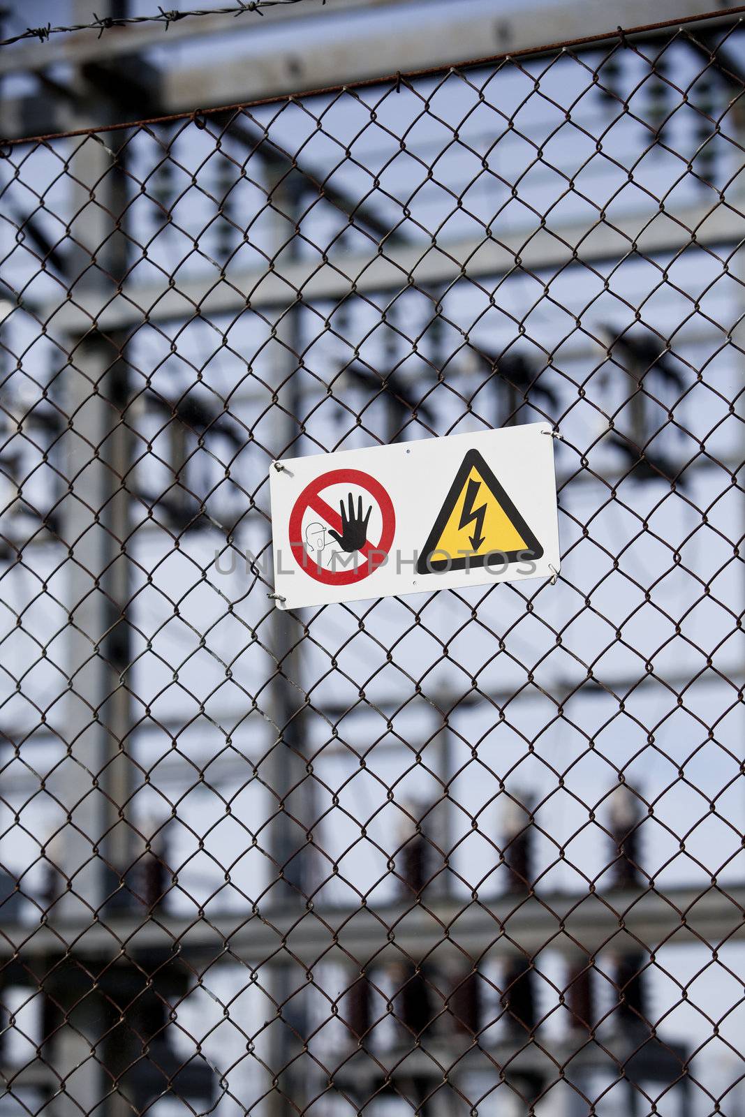 Warning signs on a fence with short focal depth.