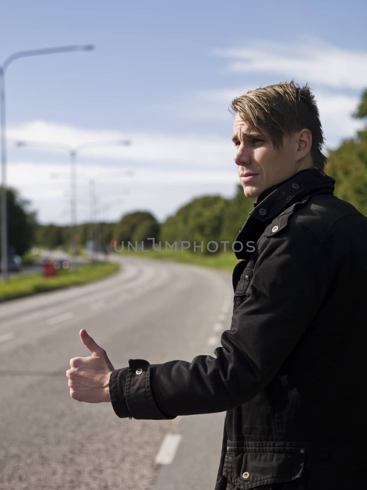 A young man hitchiking on the road