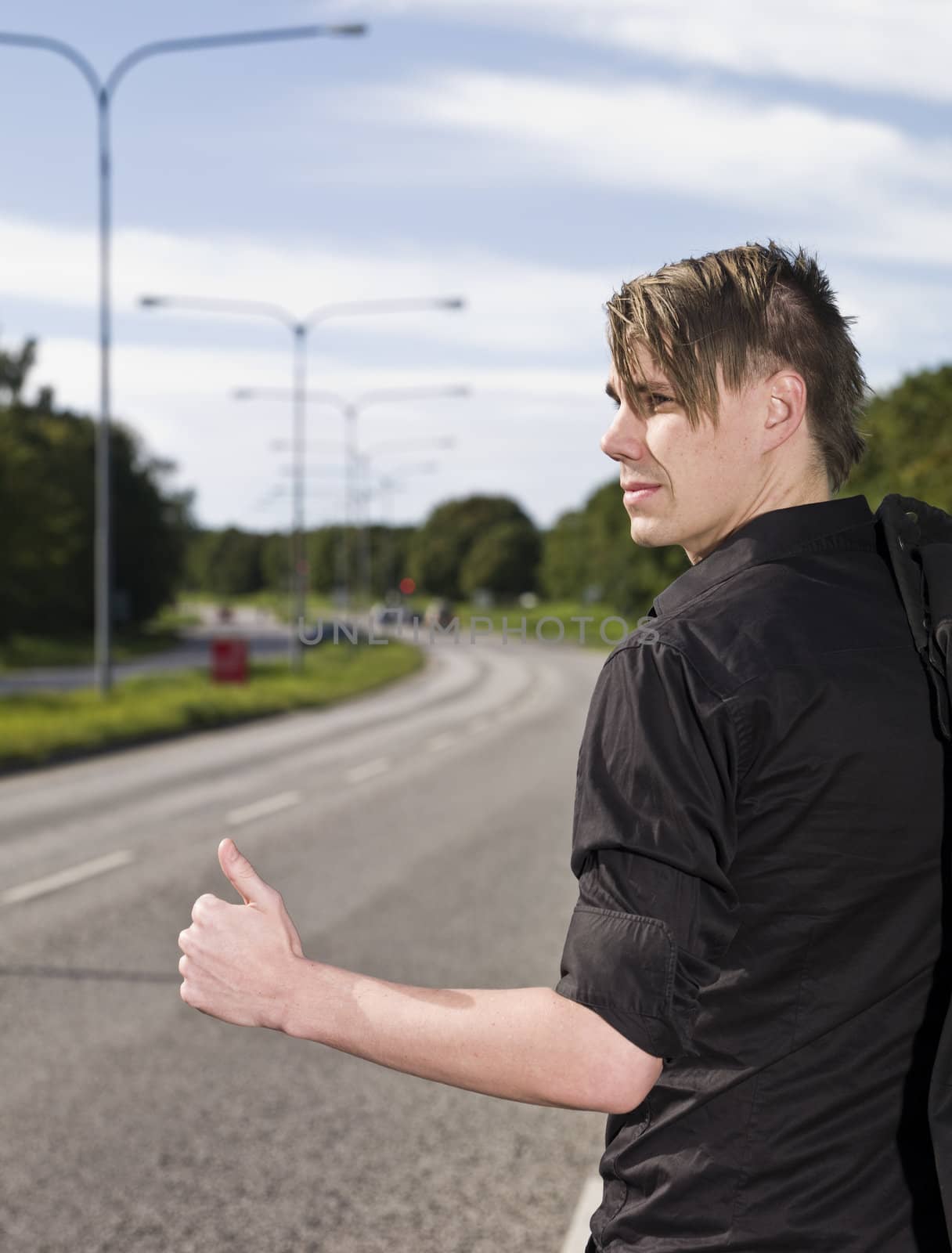 A young man hitchiking on the road