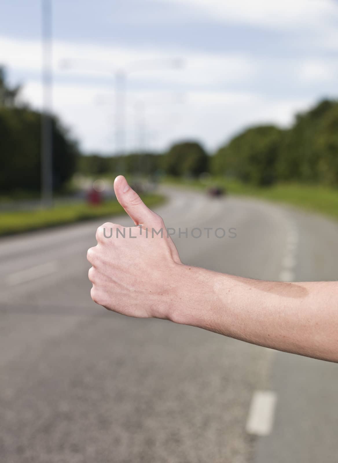 A young man hitchiking on the road