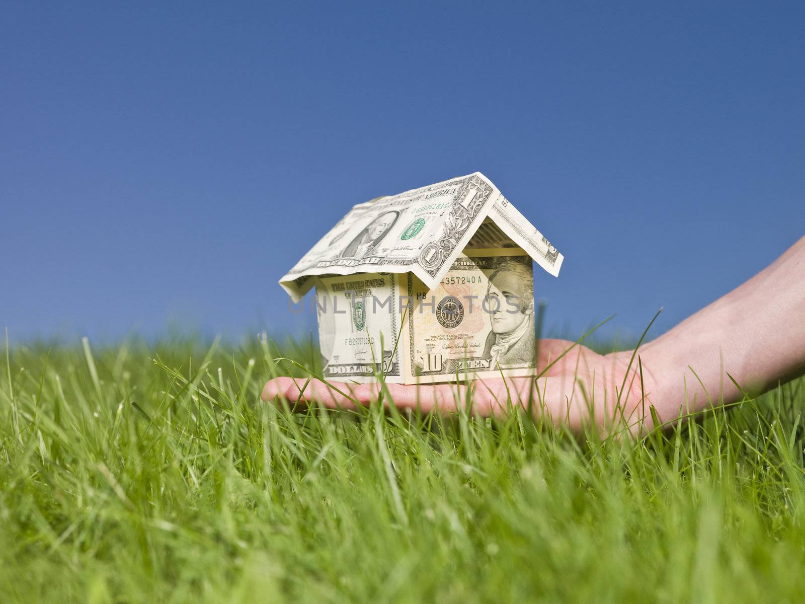 Man holding a dollar house outside