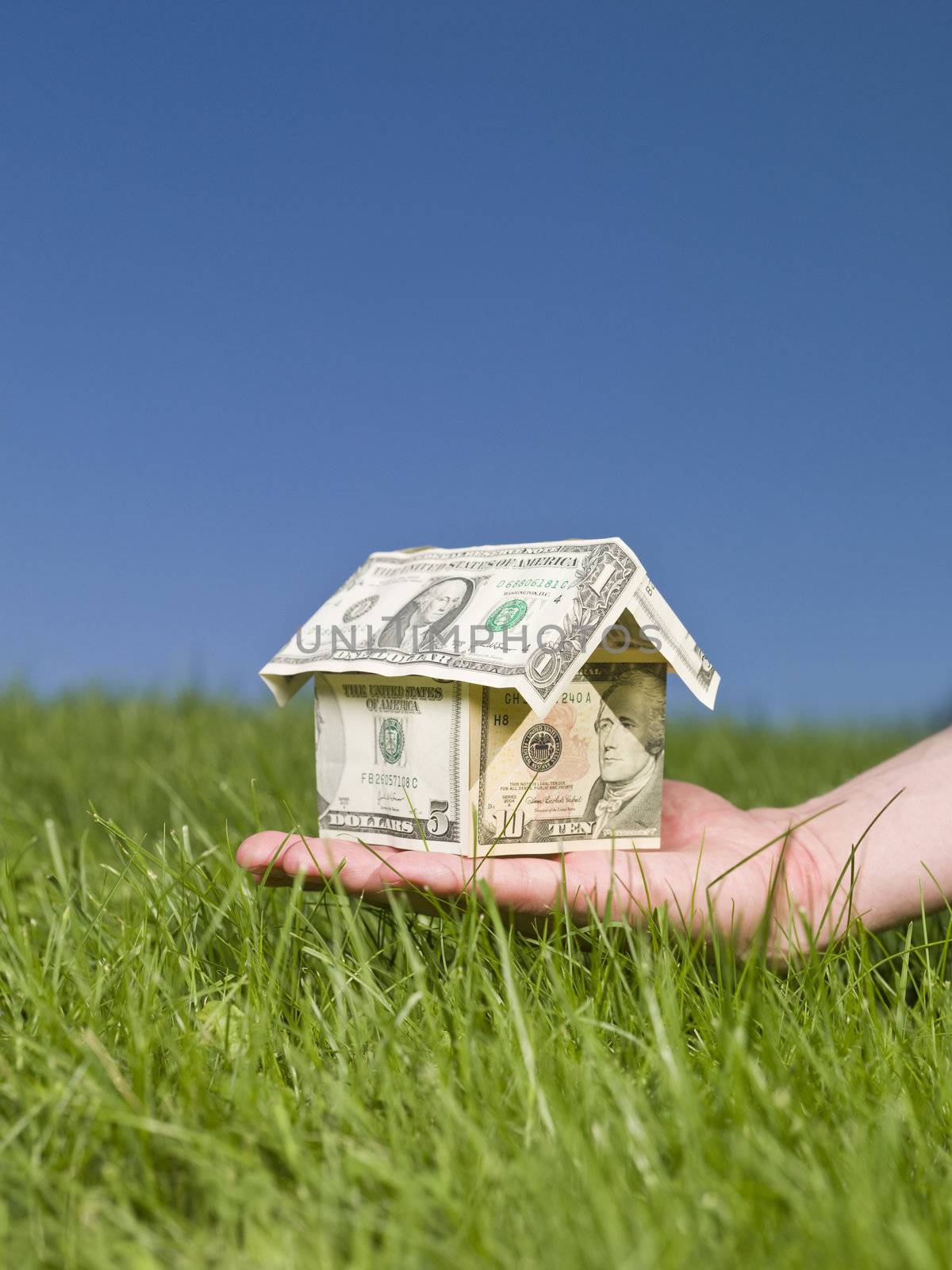 Man holding a dollar house outside