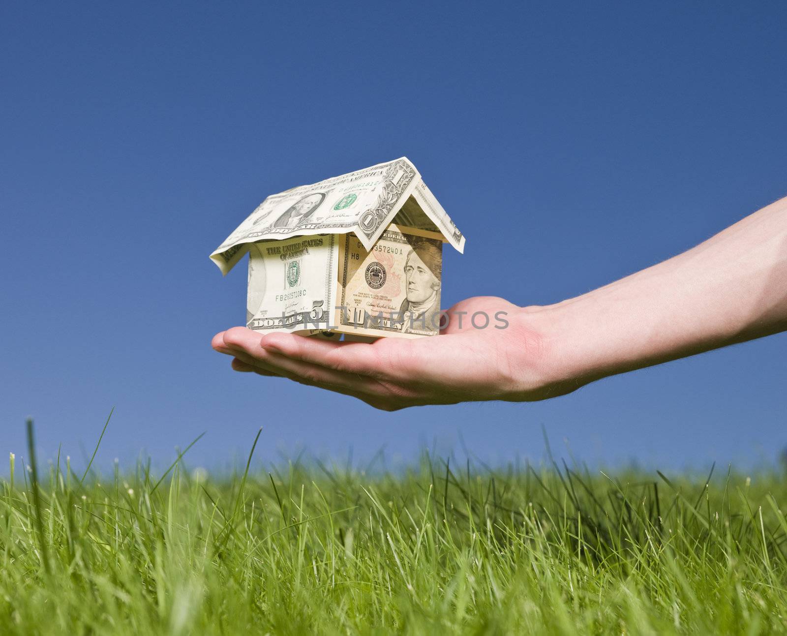 Man holding a dollar house outside