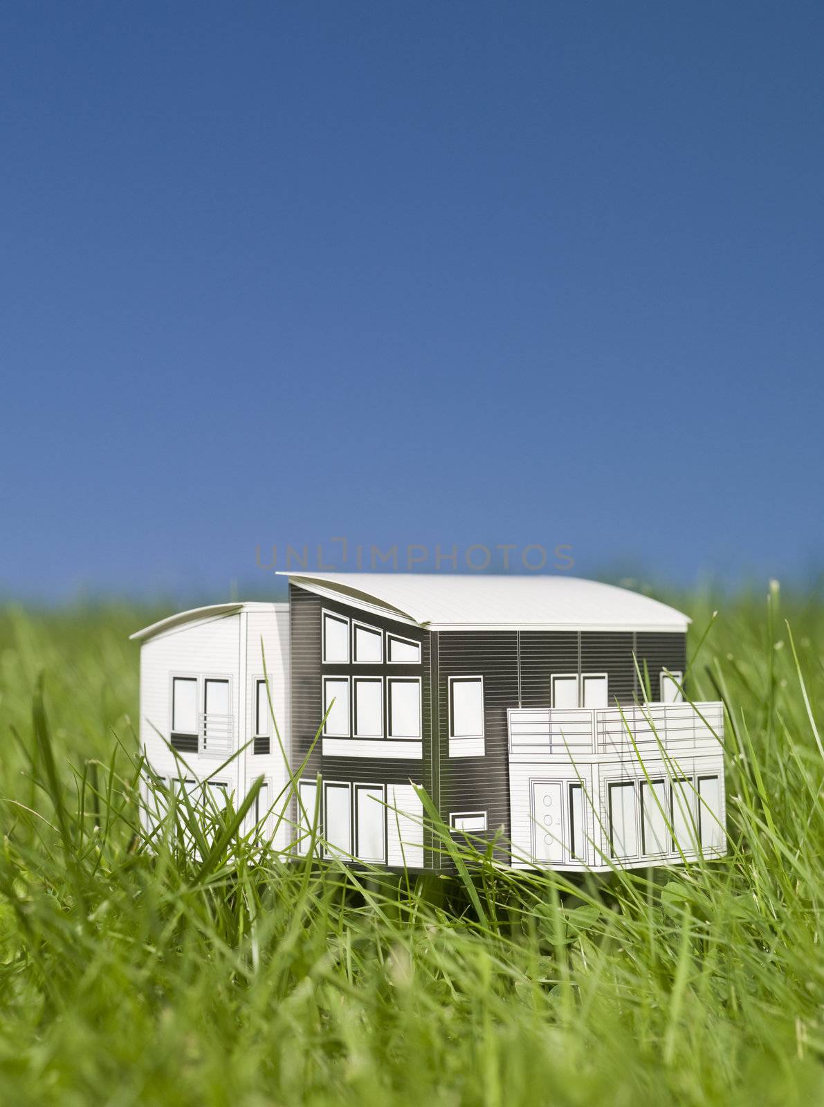 A miniature house outside in the sun.