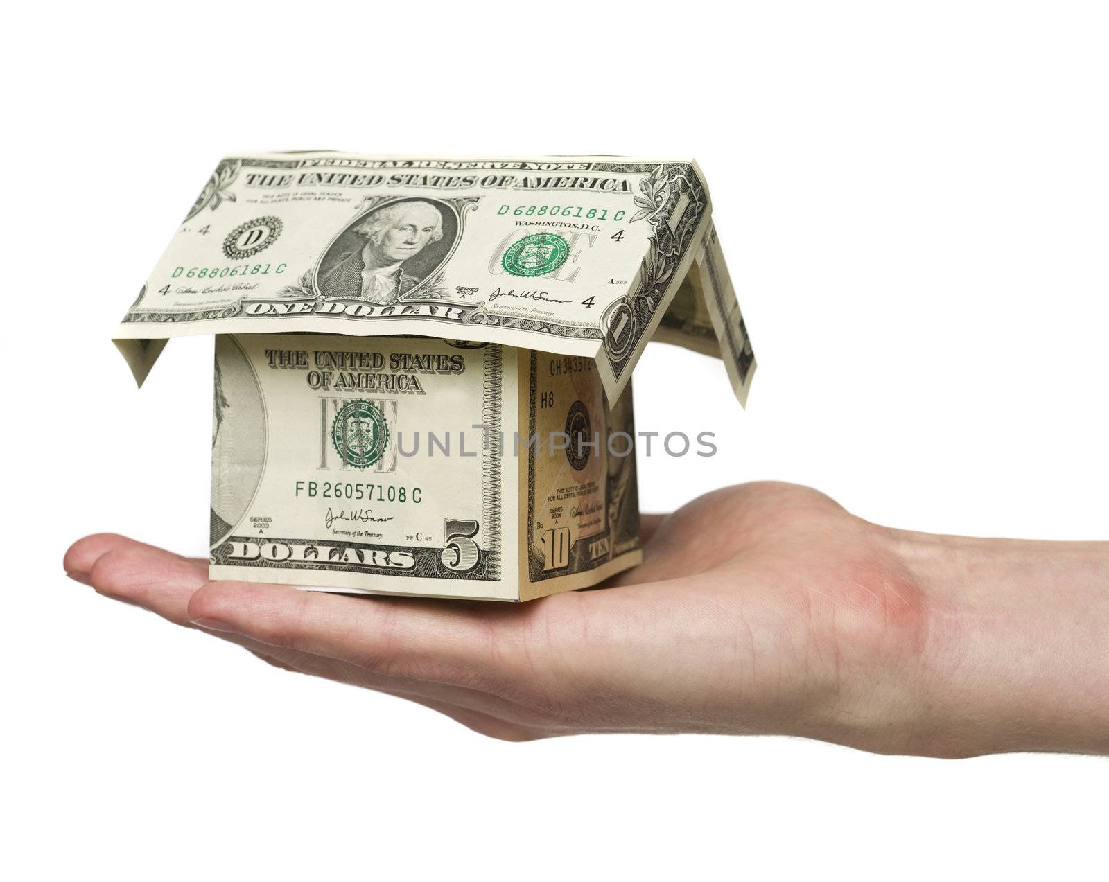 Man holding a small house built out of dollar bills