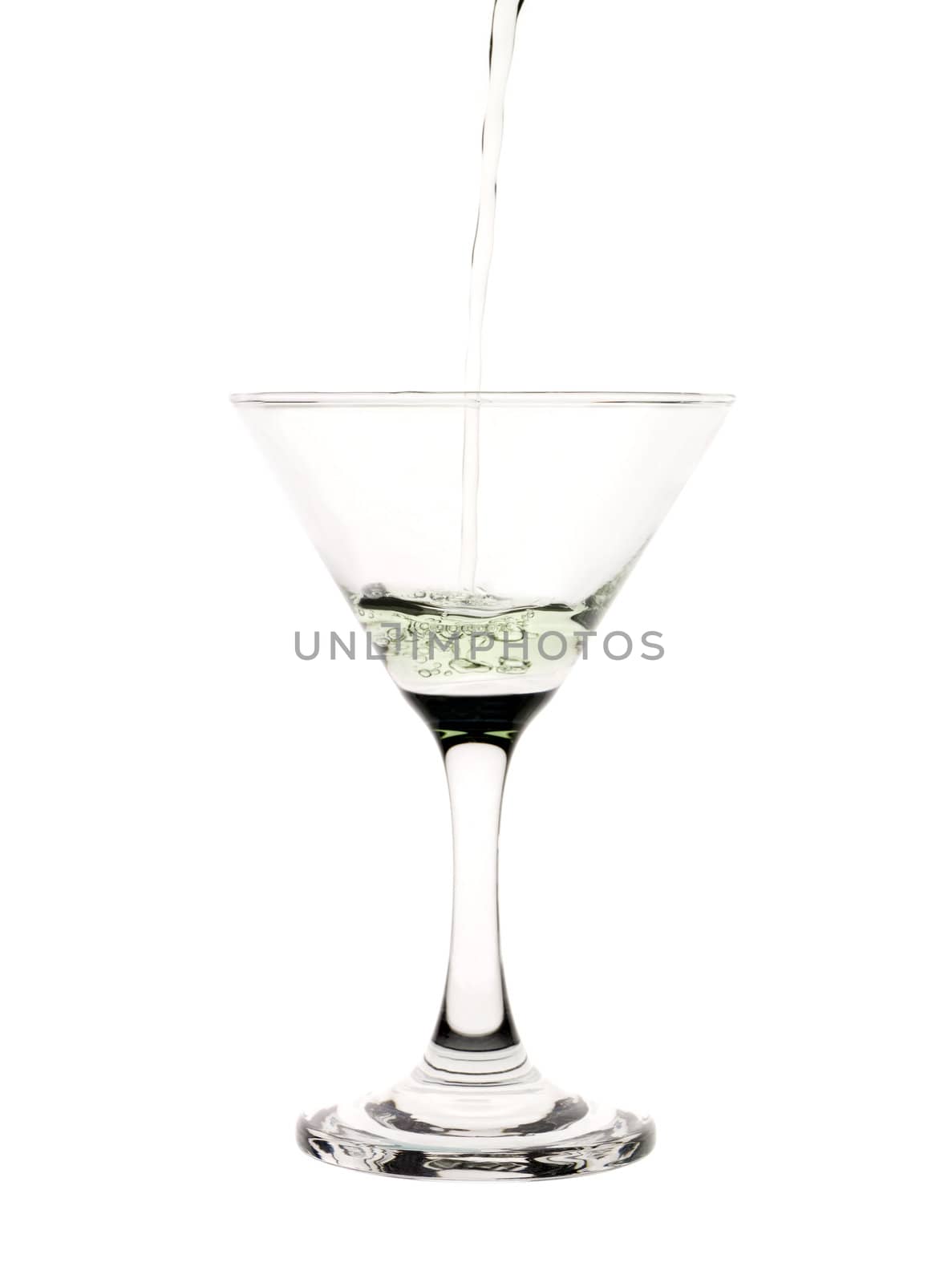 Green liquid pouring into a martini glass.
