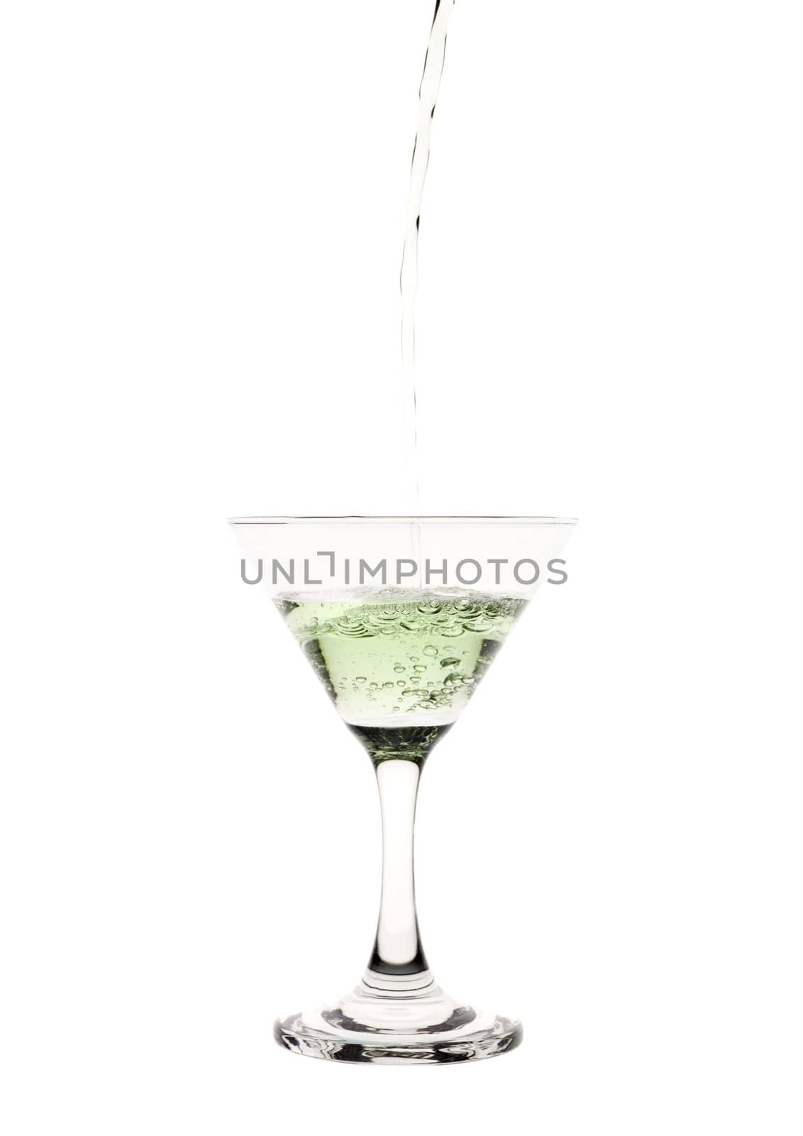 Green liquid pouring into a martini glass.