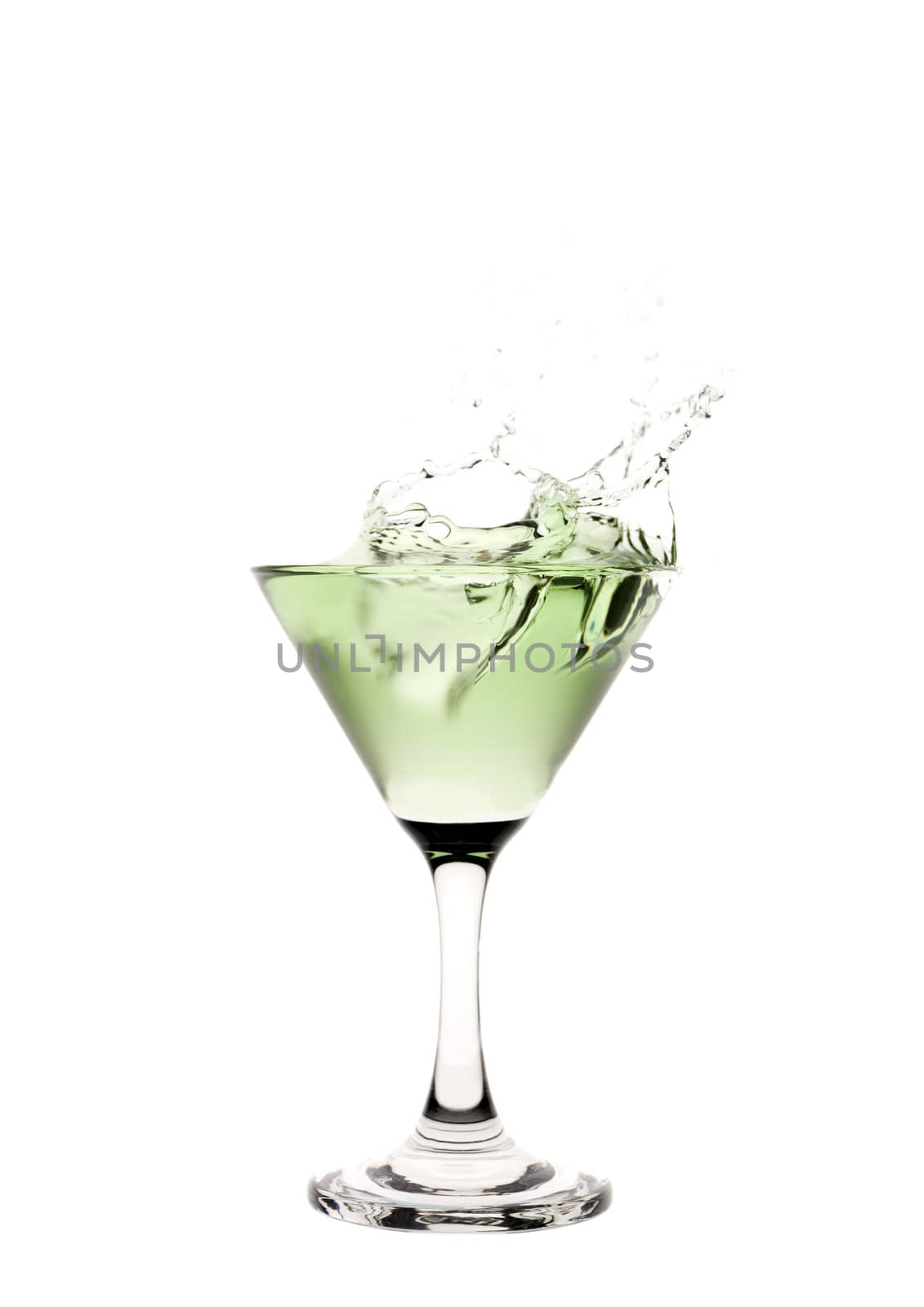 Green liquid splashing in a martini glass.