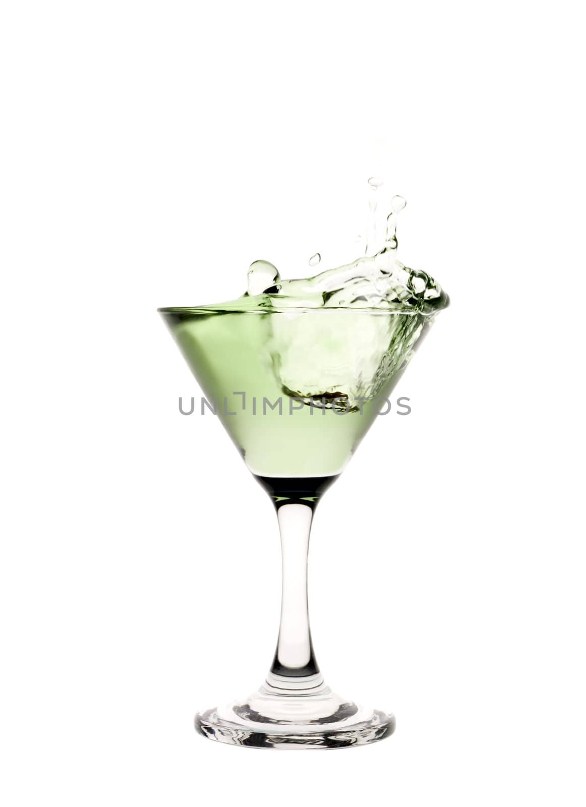 Green liquid splashing in a martini glass.