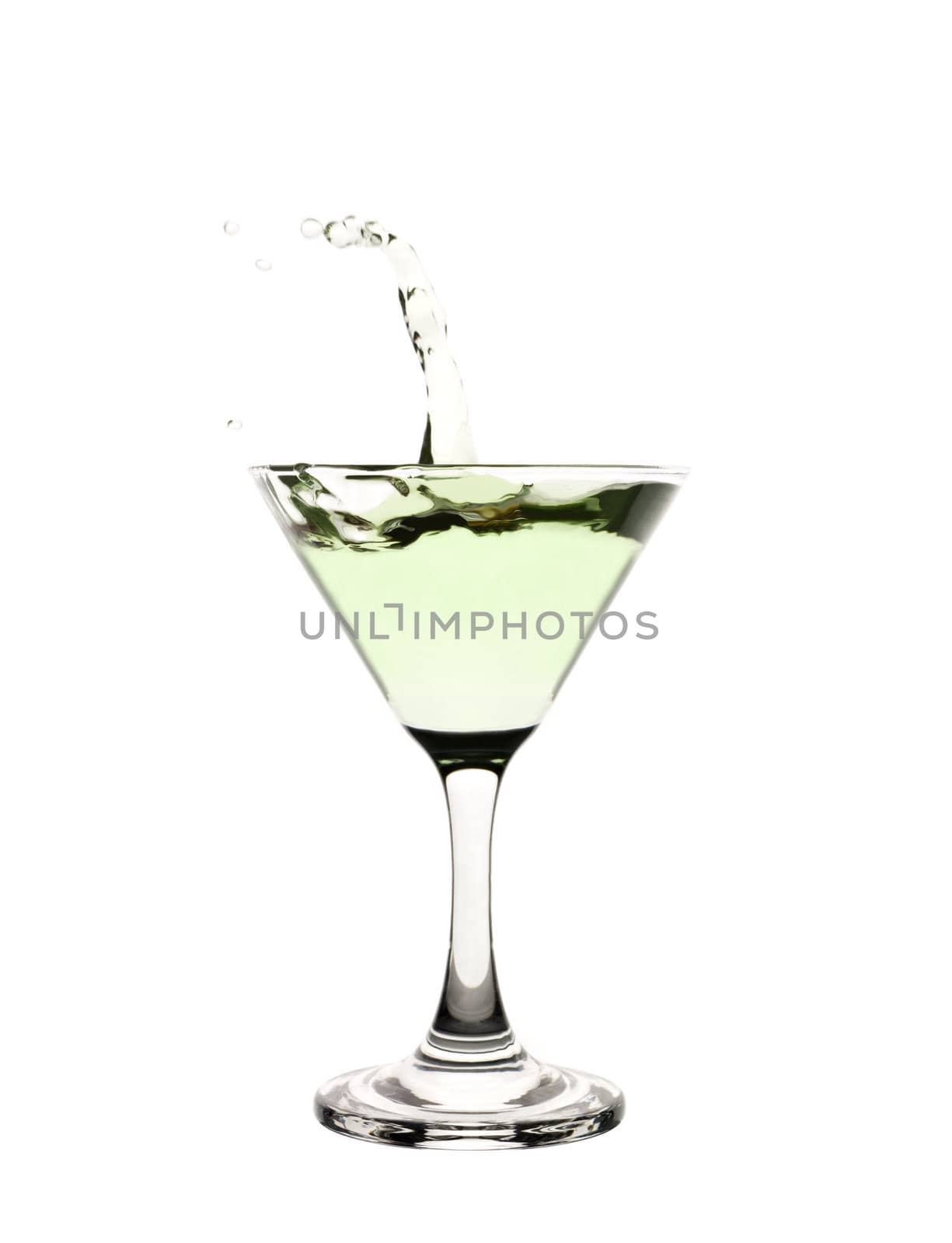 Green liquid splashing in a martini glass.