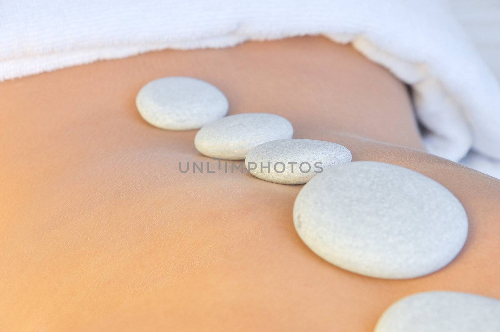 young woman in a spa having hot stones treatment 