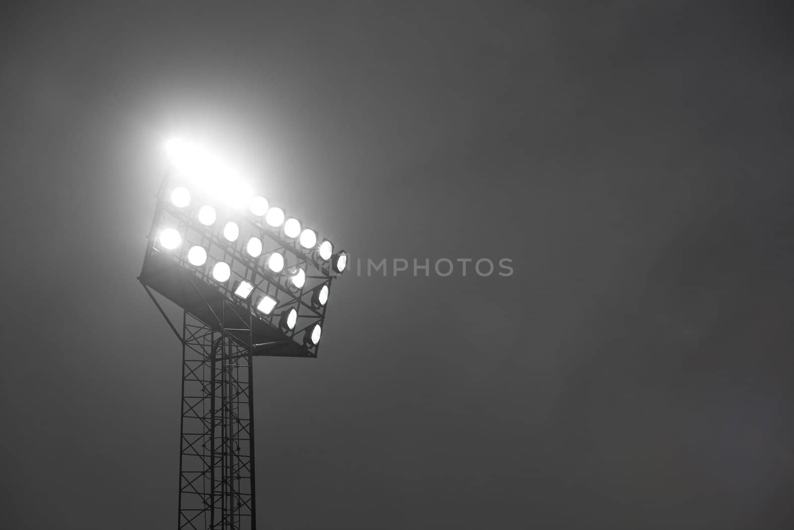 Stadium spotlights lit at night.