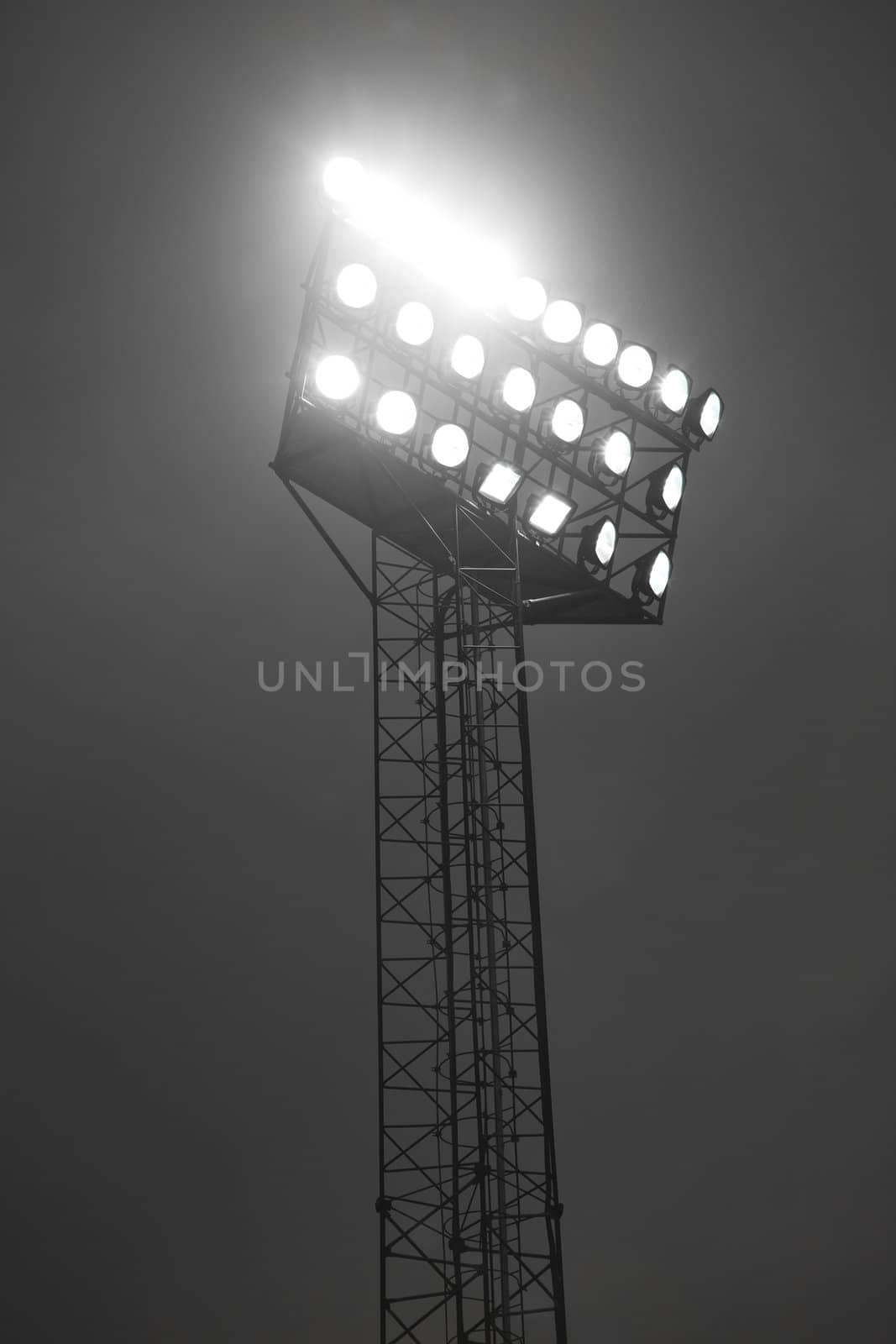 Stadium spotlights lit at night.
