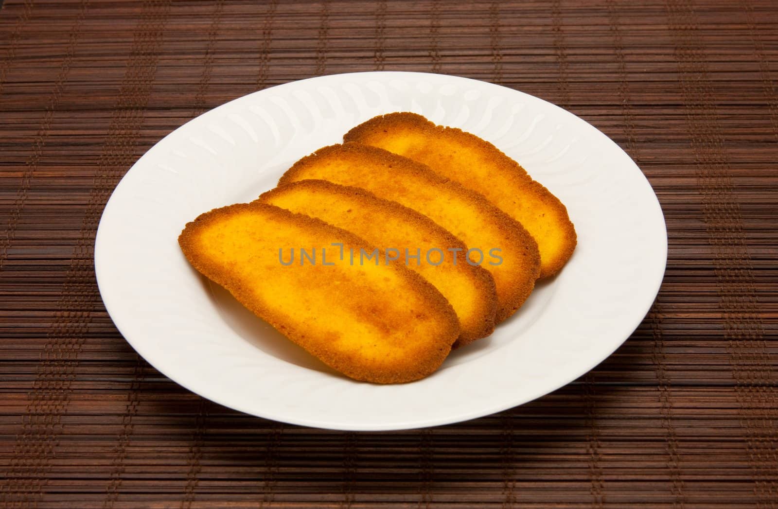 A plate of cookies on dark brown background