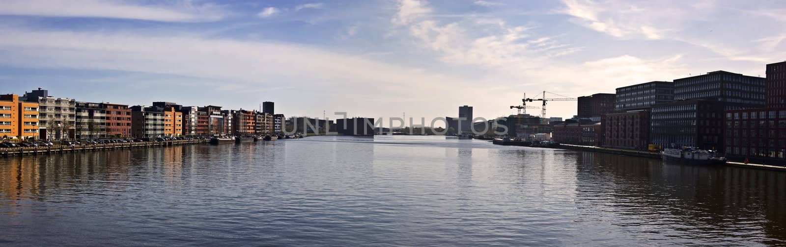 Modern architecture in Amsterdam. Island of Borneo. Modern housing is reflected in the water against the blue sky.