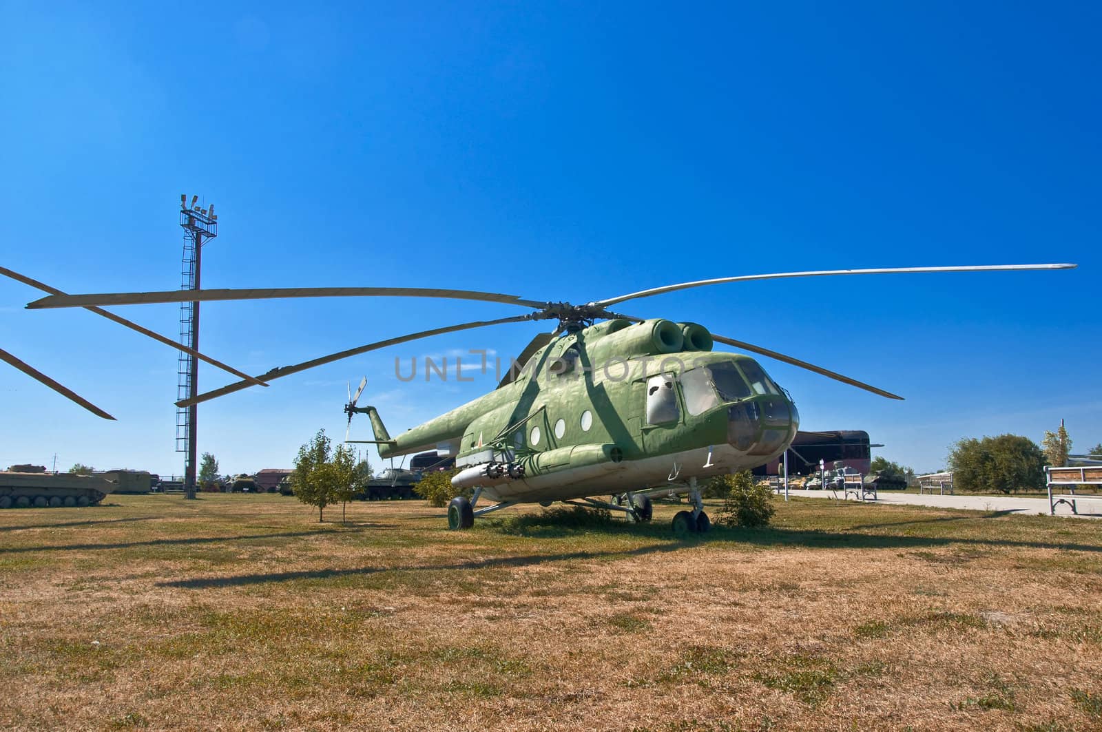 old Russian helicopter on the grass. Against the background of blue sky.