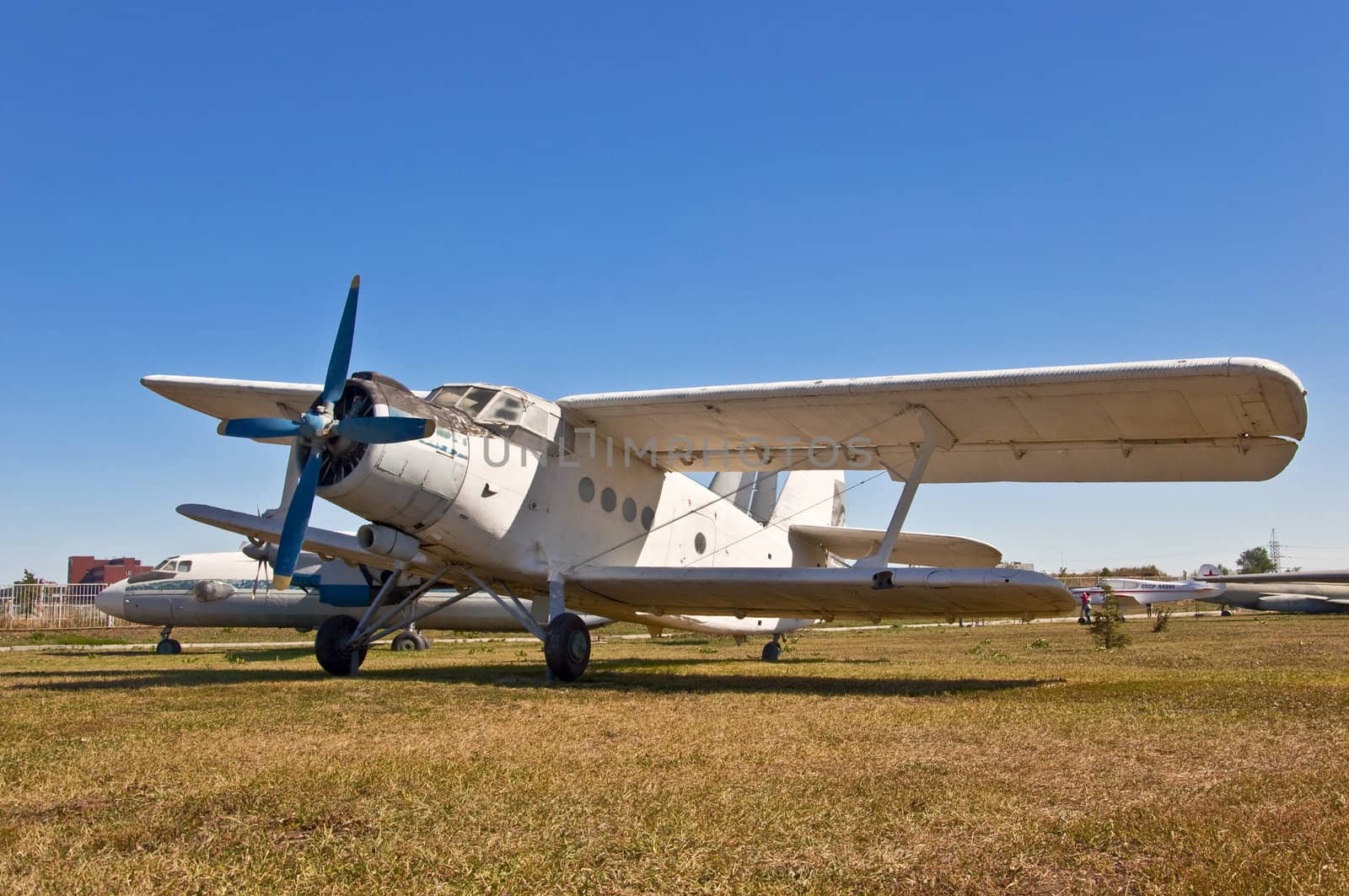 old russian airplane on grass and blue sky background