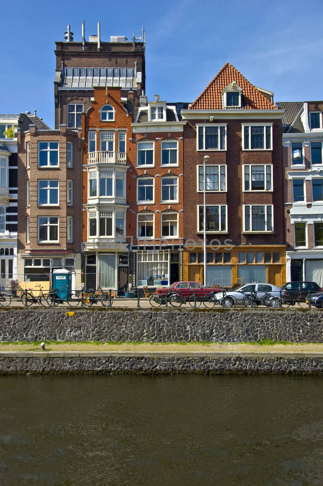 Classic amsterdam view. Residential homes on the canal. Urban scene. Spring.