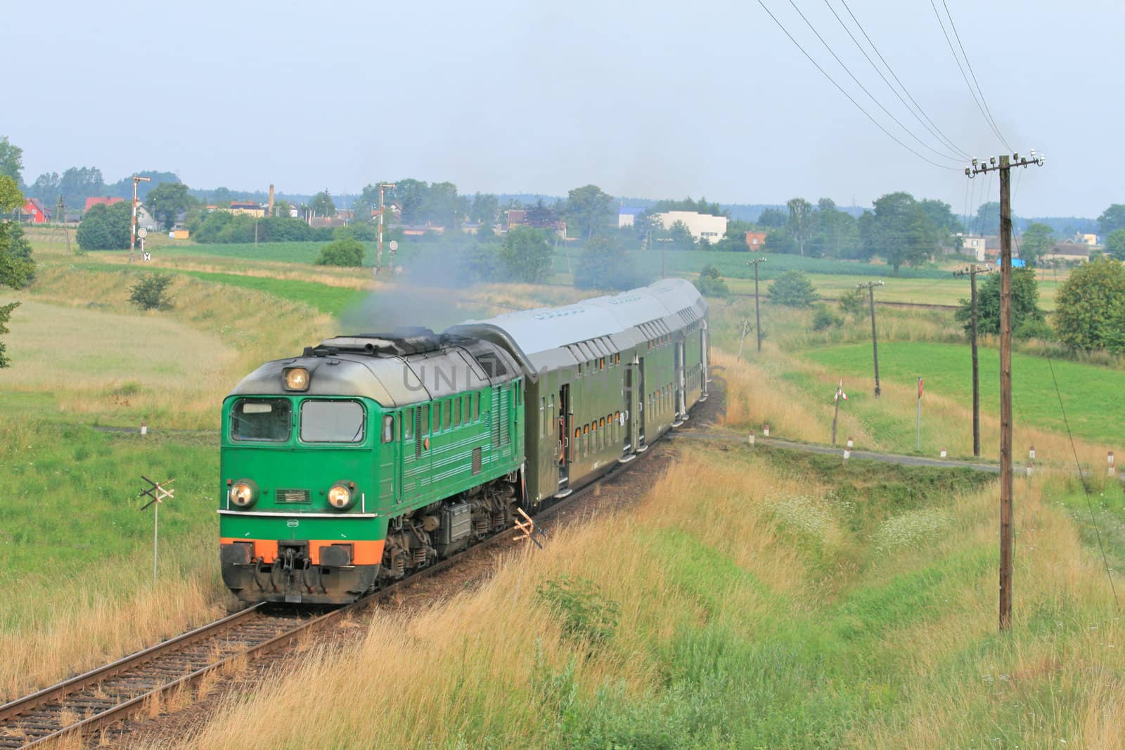 Passenger train passing through polish countryside
