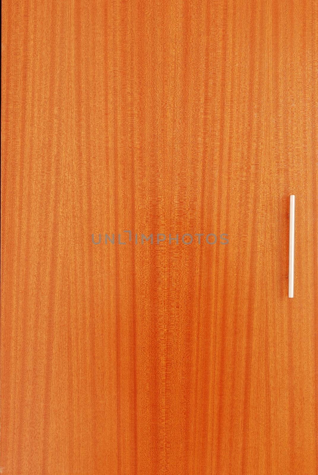 close up of a wooden wardrobe door with a metal handle