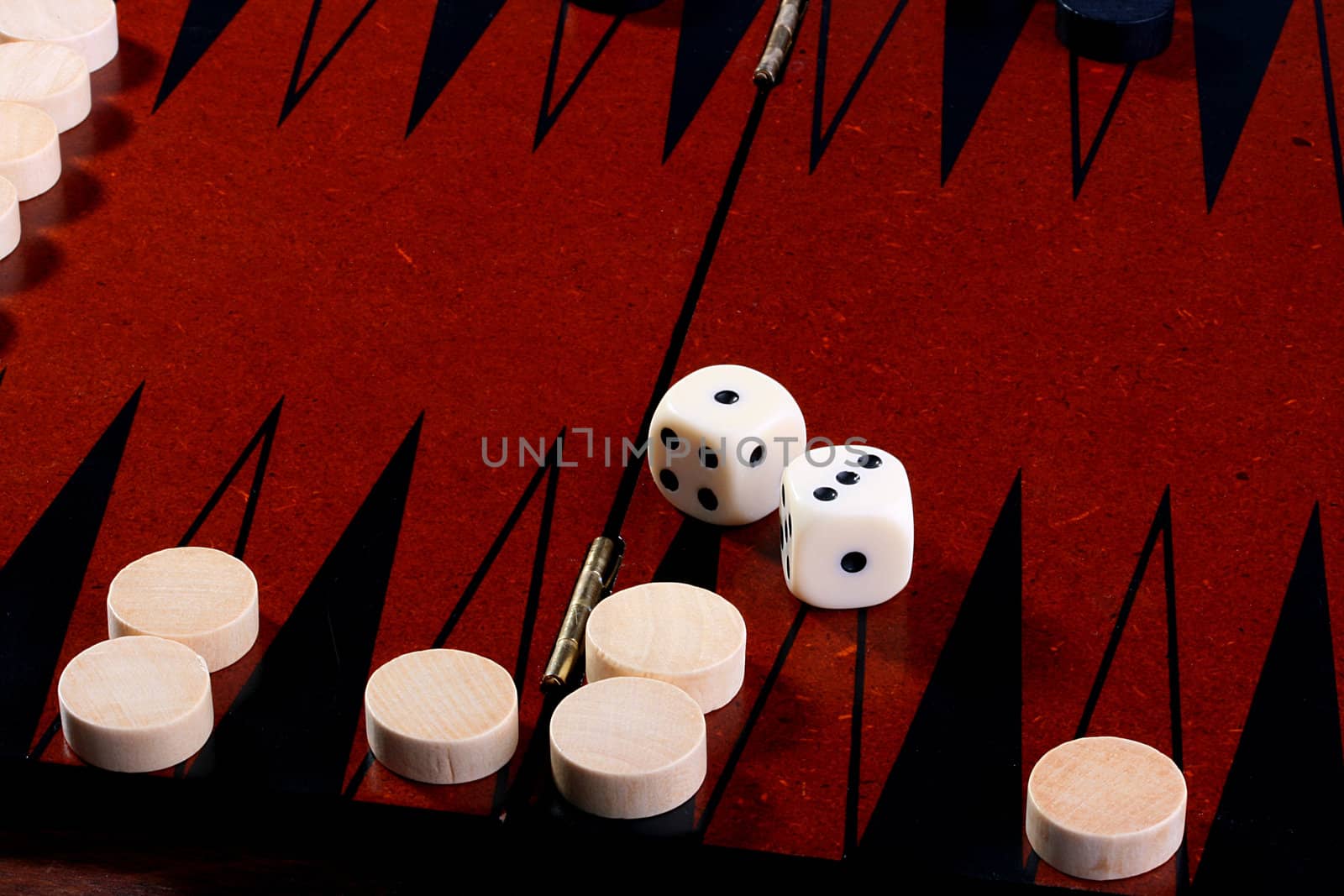 Backgammon, in the foreground in focus black counters, on a background of a counter of the contender and cubes.