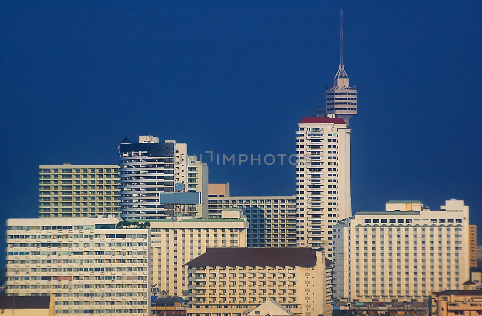 Tower and skyscrapers with vibrant blue sky.