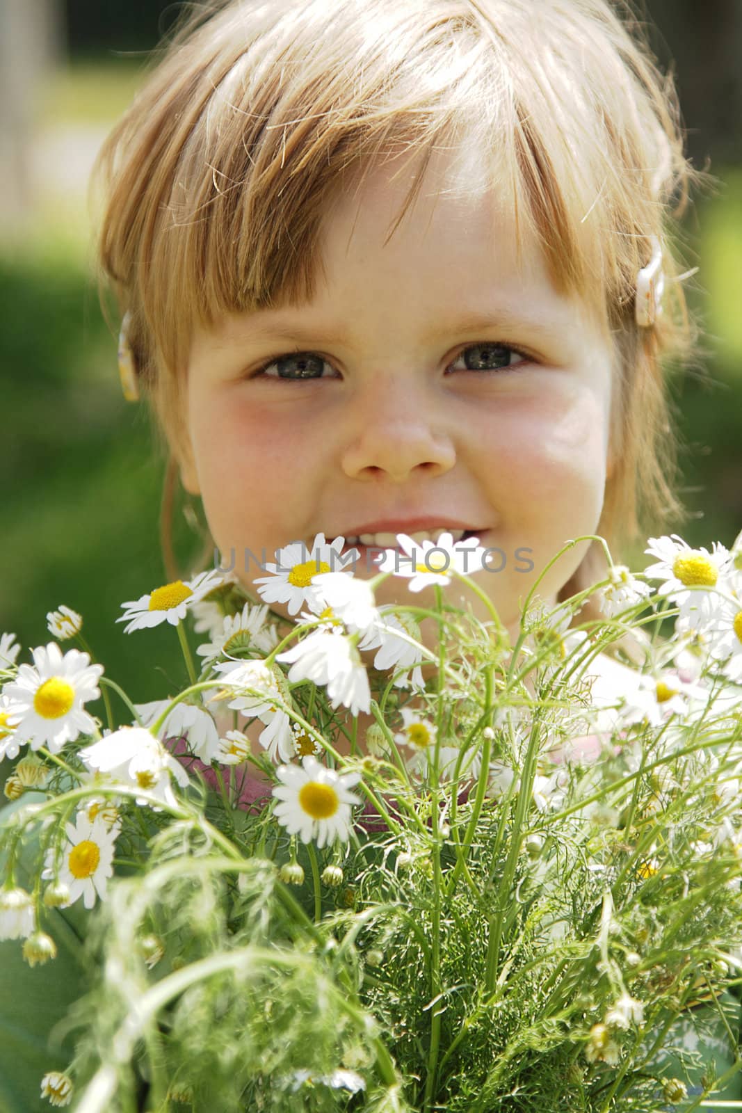 Cute little girl with white daisies outdoor