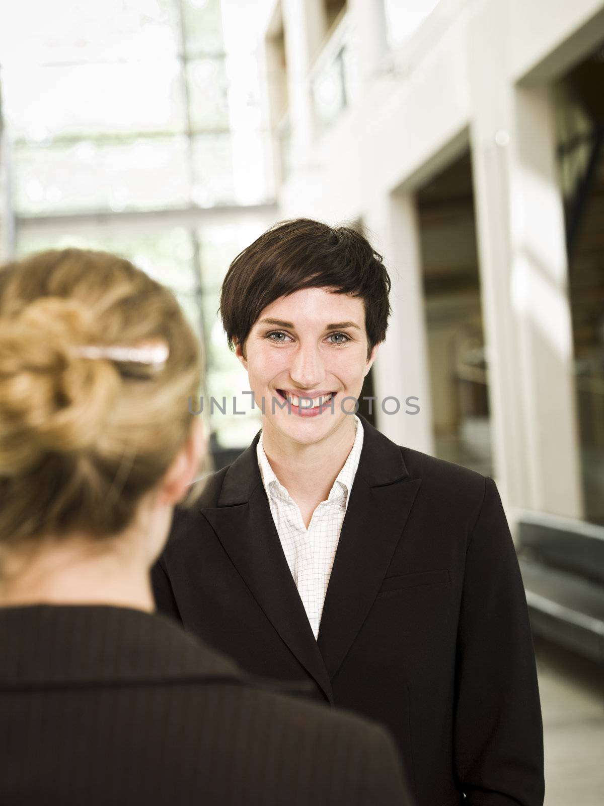 Woman facing the camera standing in a modern building by gemenacom