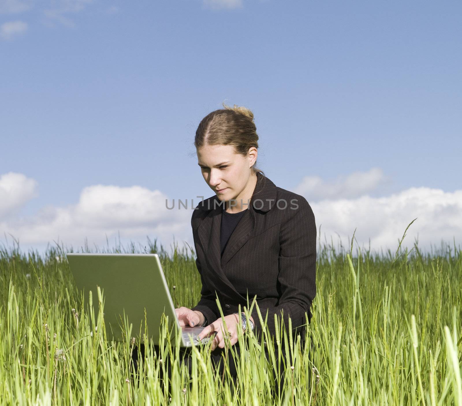 Woman with her laptop in the grass by gemenacom