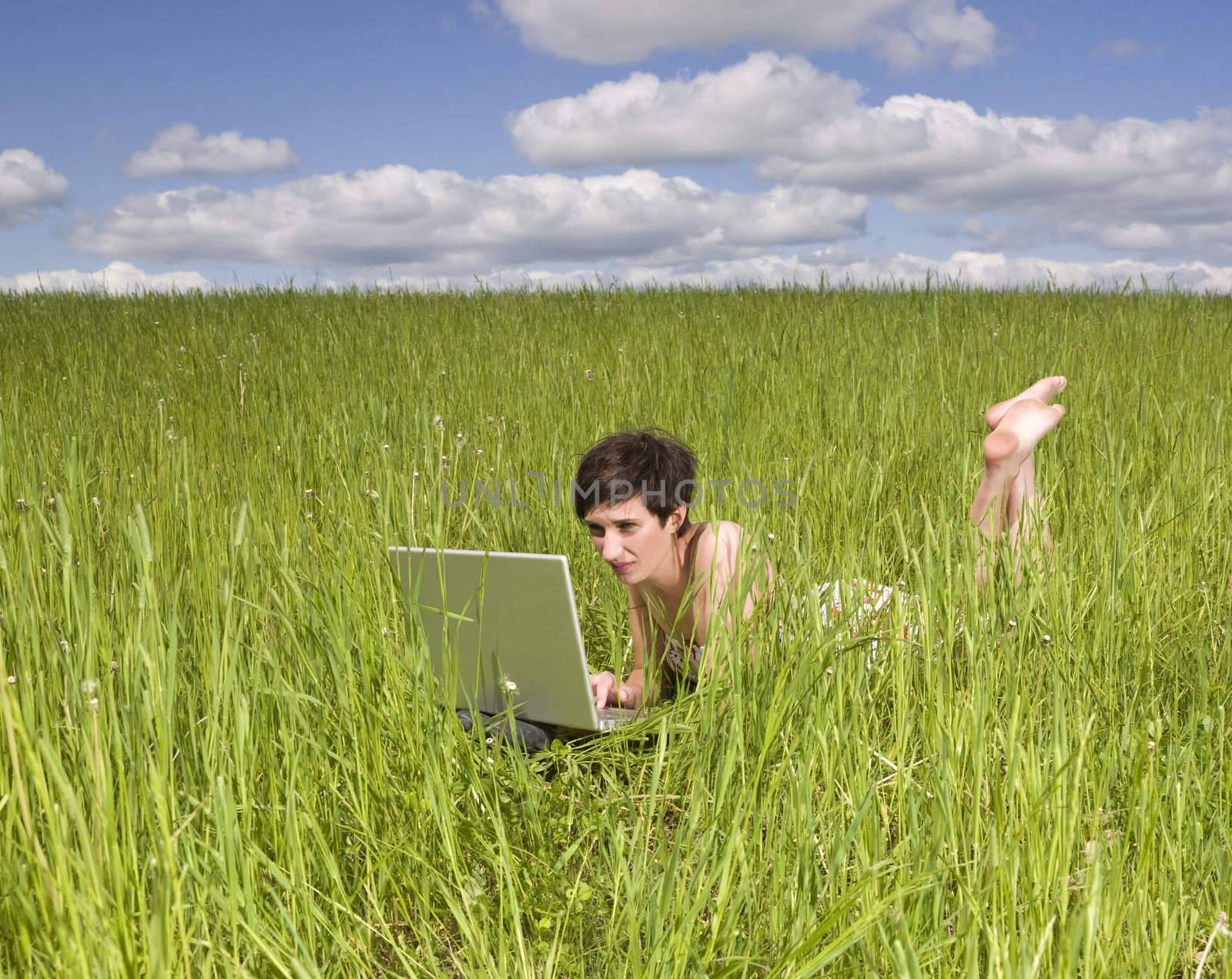Woman with her computer in the grass