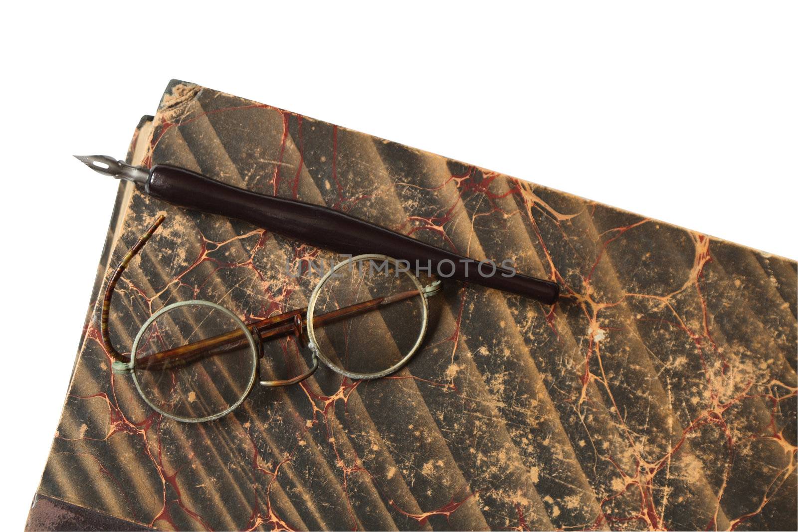 Vintage spectacles and fountain pen lying on old book. Isolated with clipping path