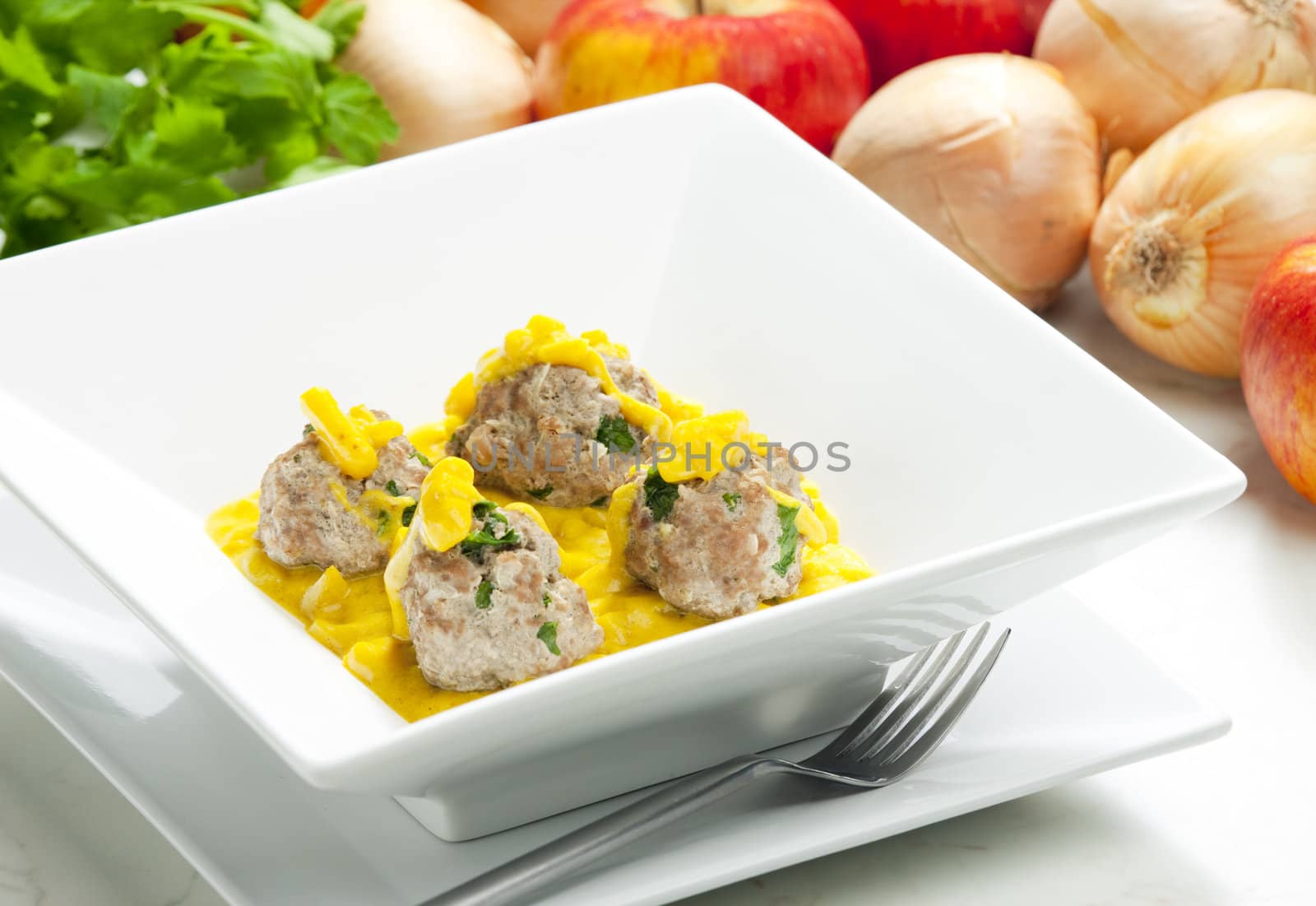 minced meat and herbs balls in apple and curry sauce