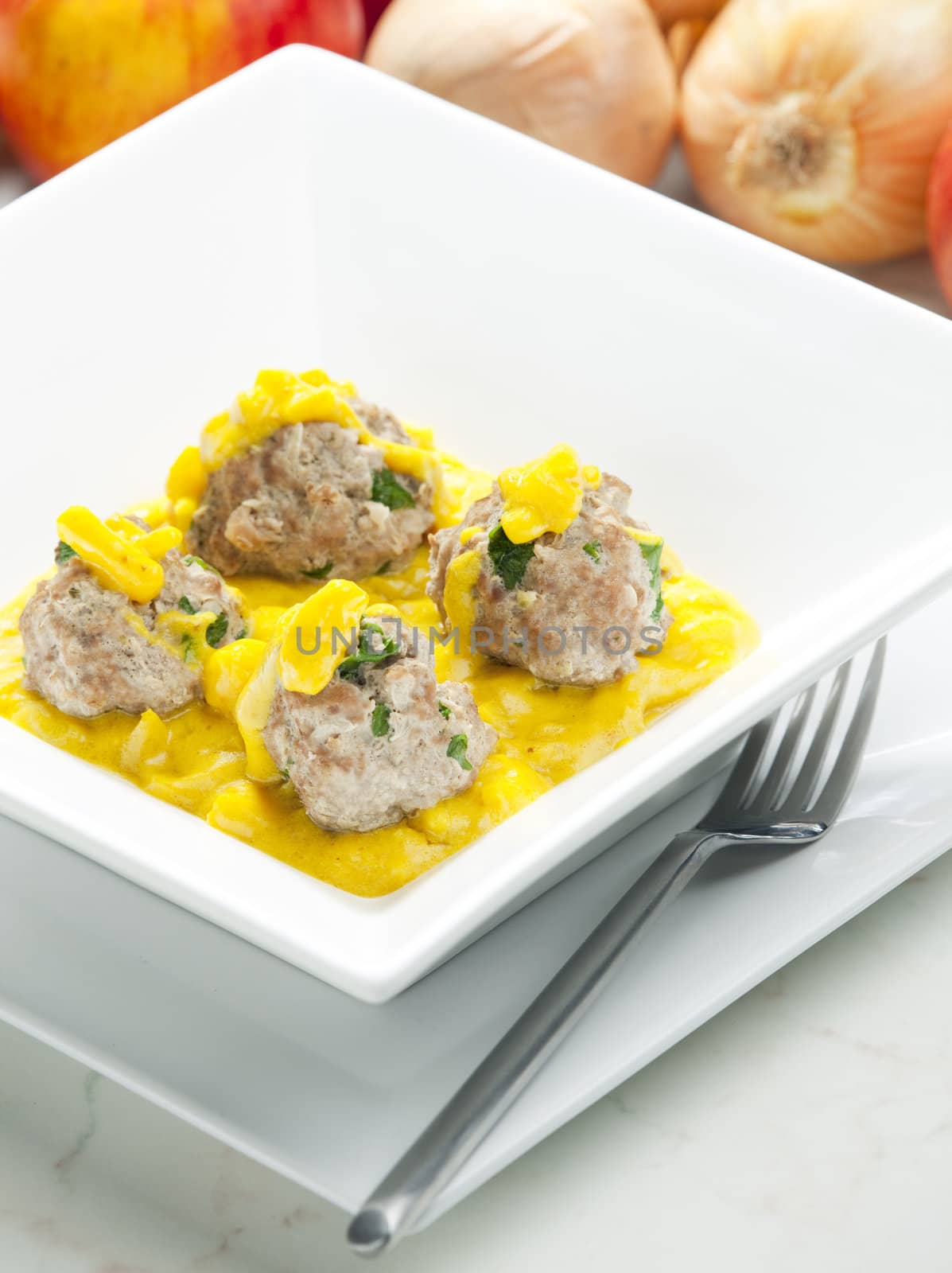 minced meat and herbs balls in apple and curry sauce