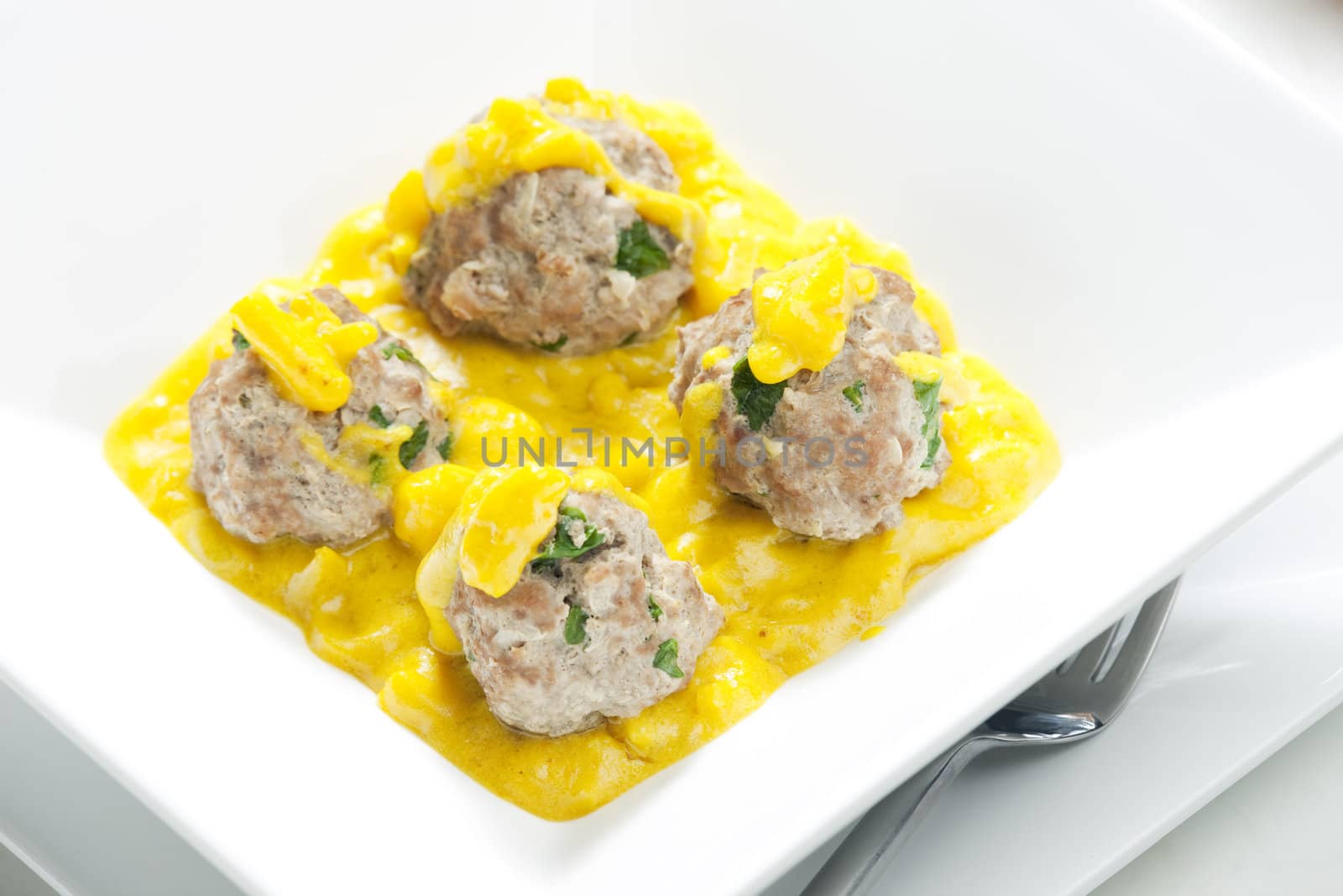 minced meat and herbs balls in apple and curry sauce