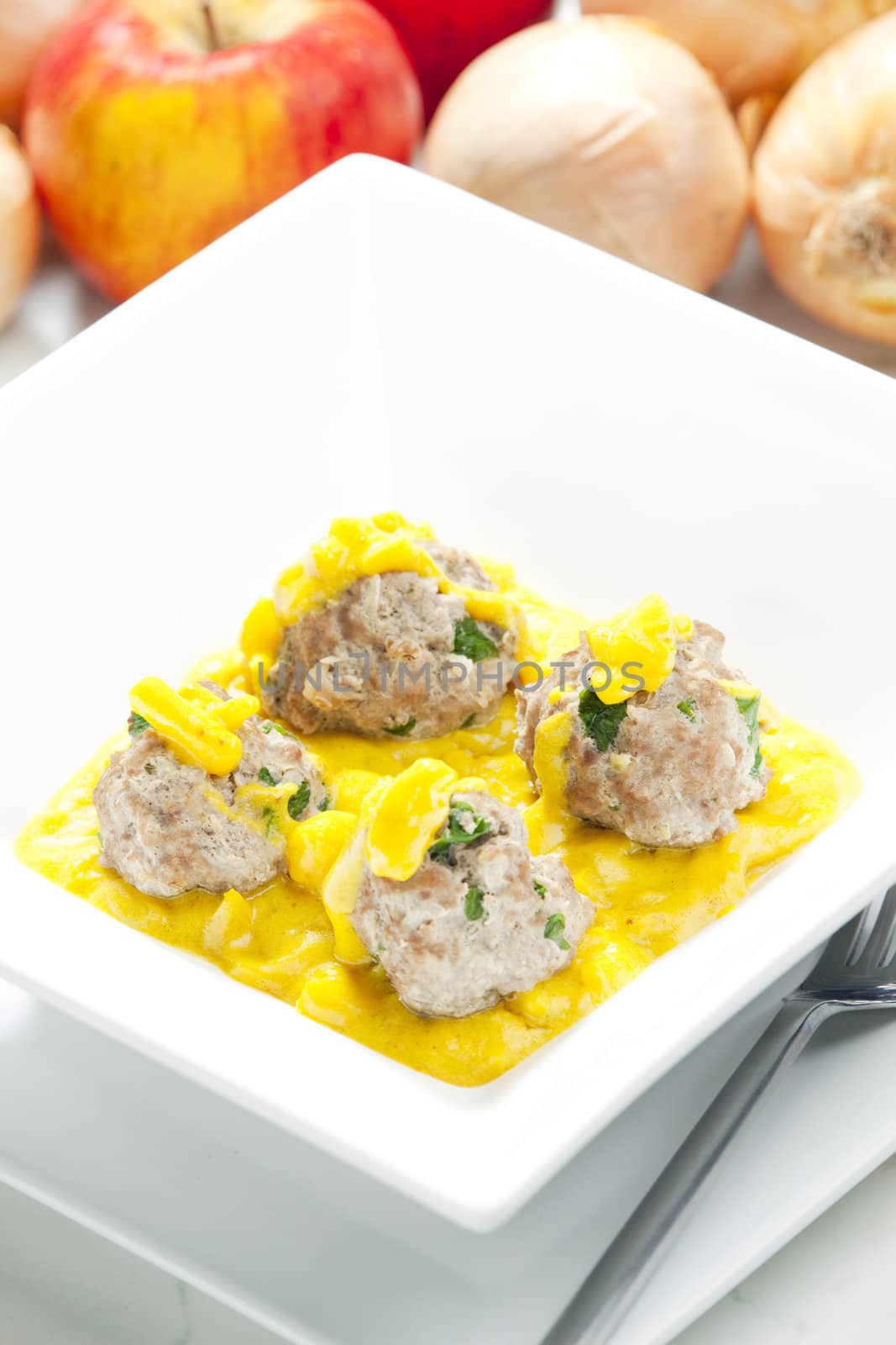 minced meat and herbs balls in apple and curry sauce