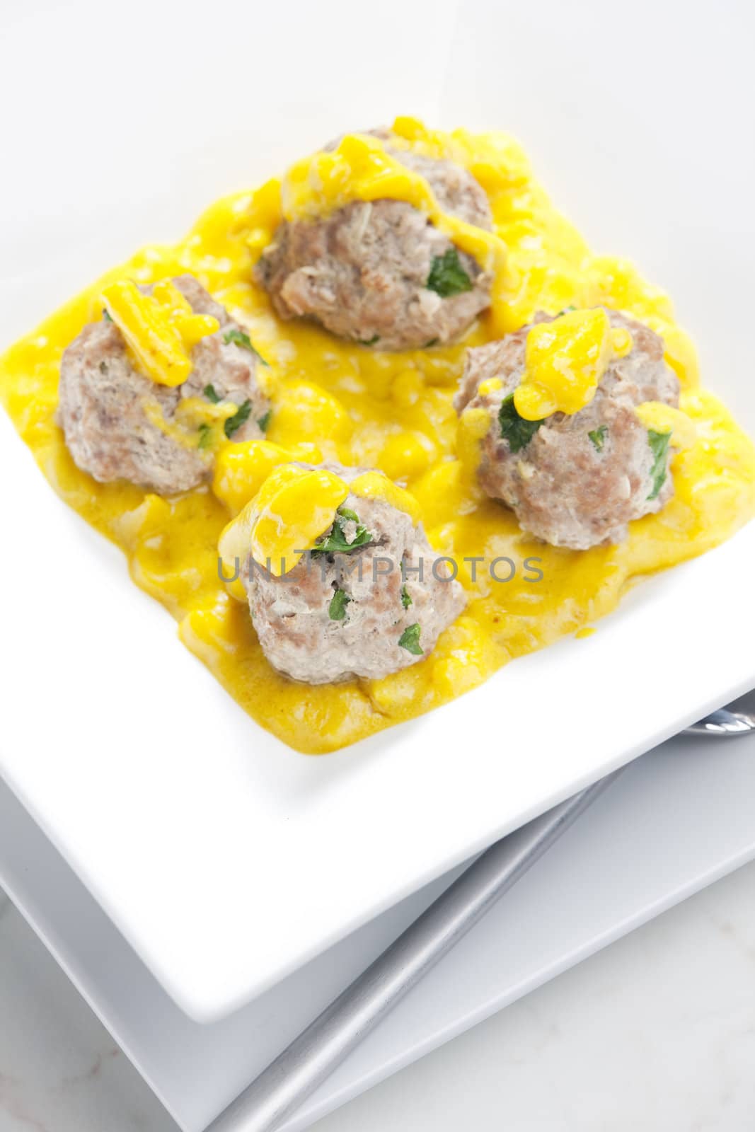 minced meat and herbs balls in apple and curry sauce