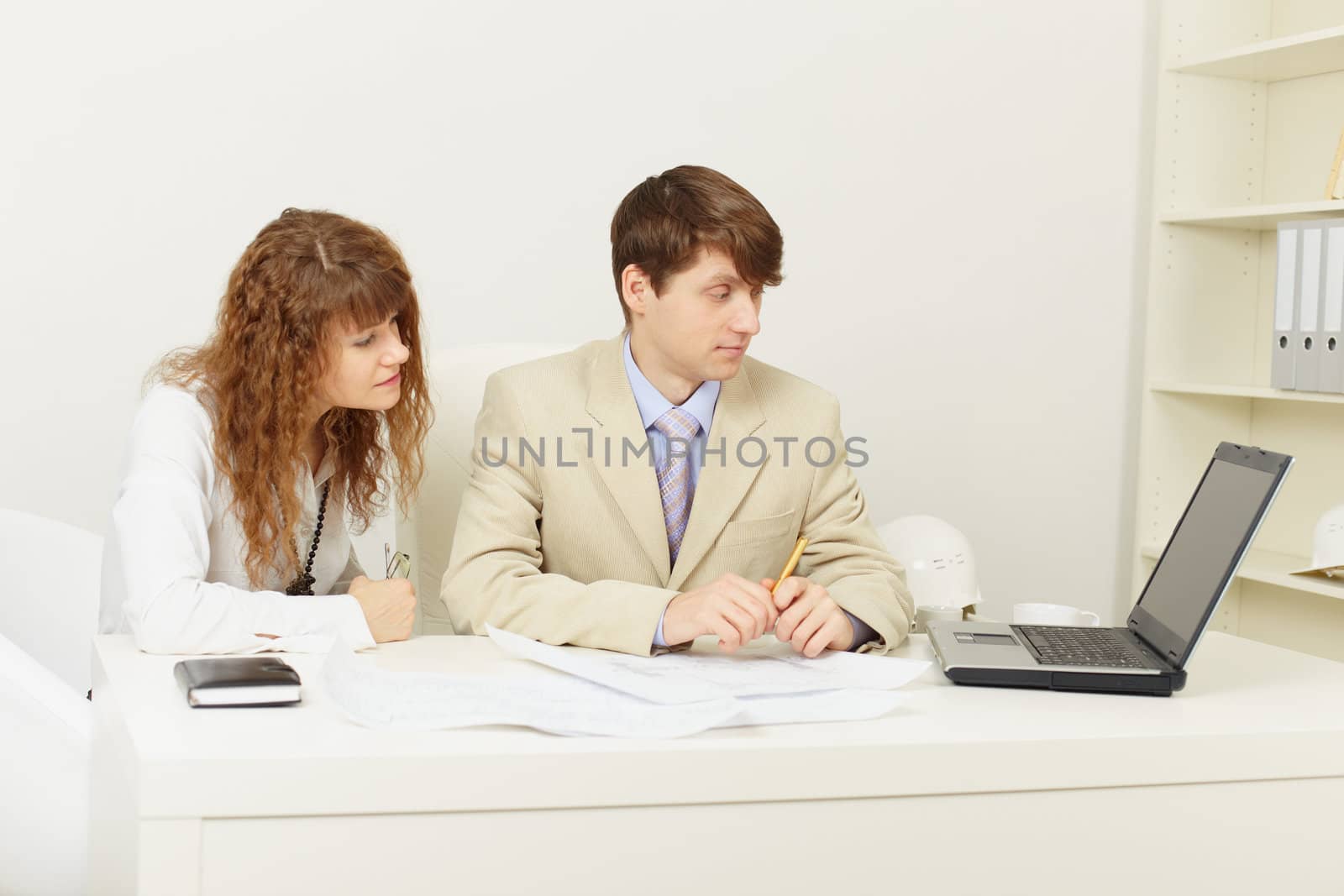 Pair of young businessmen work at office with the laptop