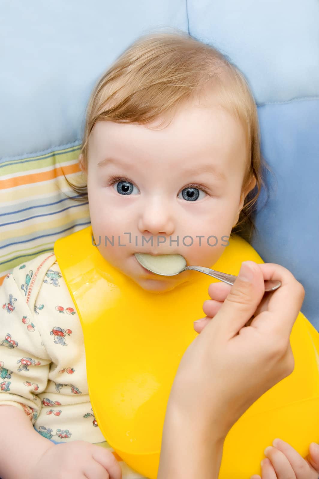 Mother's hand and baby boy eating