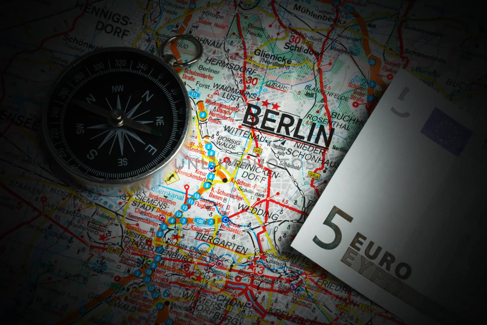 Compass and five euros on a map of Berlin