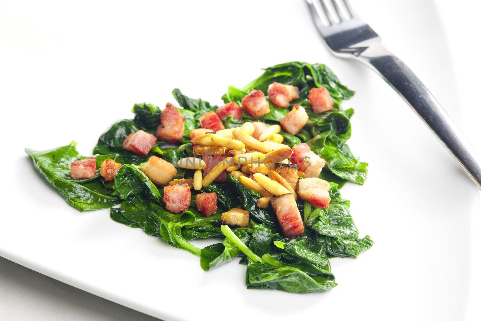 fried spinach with bacon and pine nuts