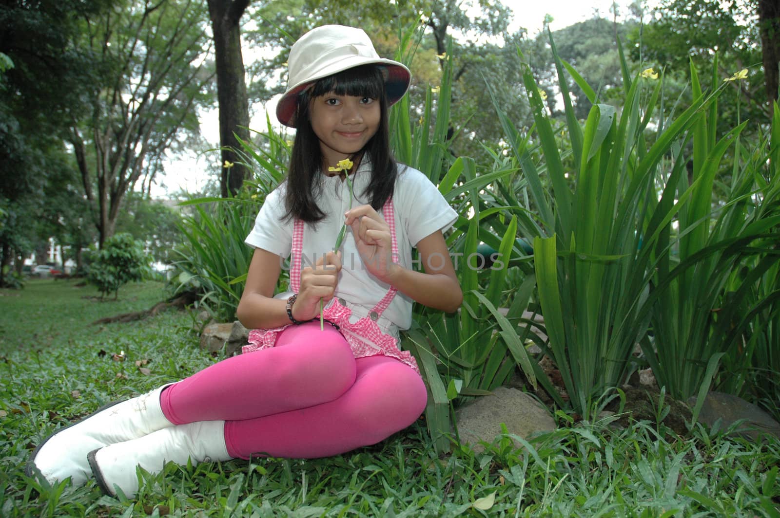 little asian girl sit down in park